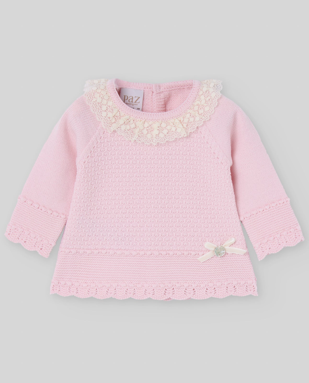 Pink baby dress with floral details on a gray background