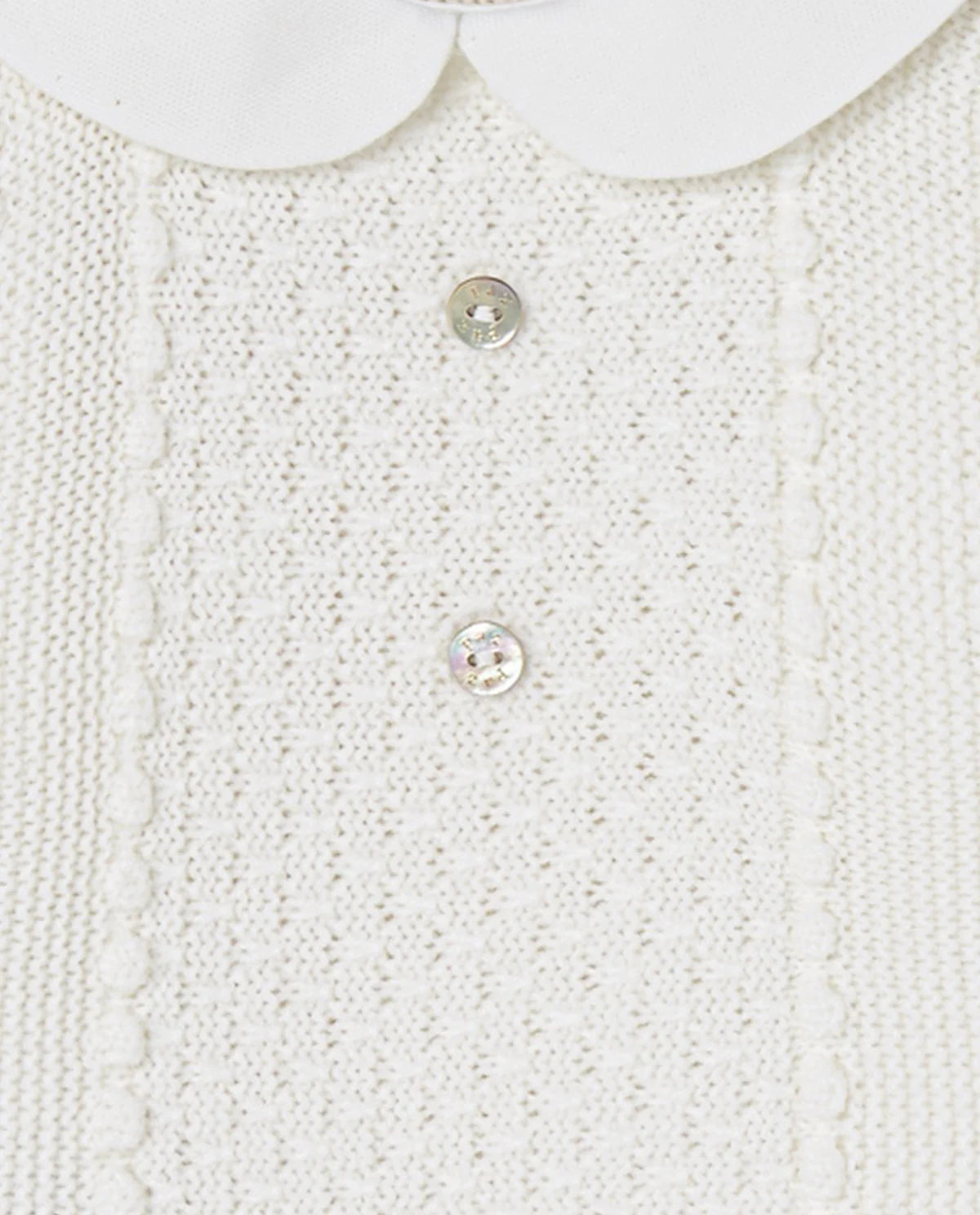 Close-up of a white textured fabric with buttons