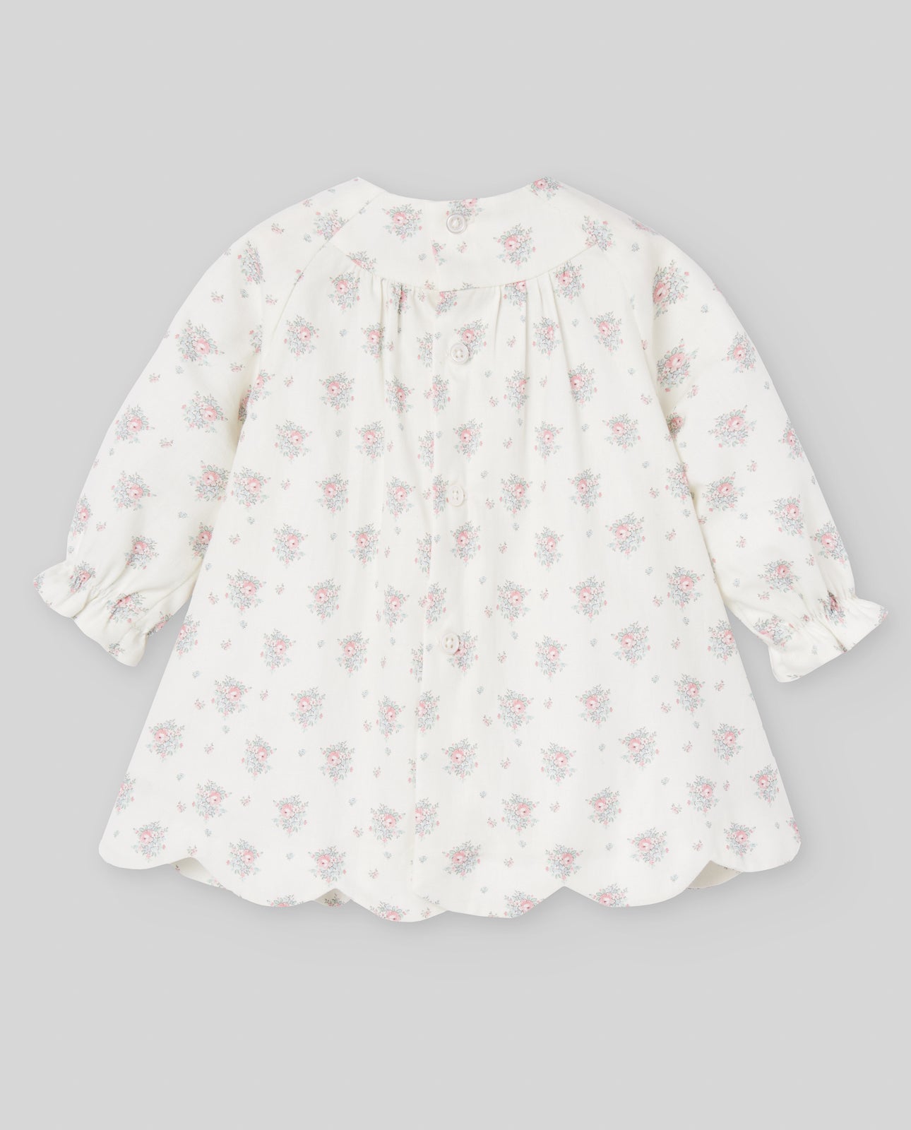 White dress with pink floral pattern on a gray background