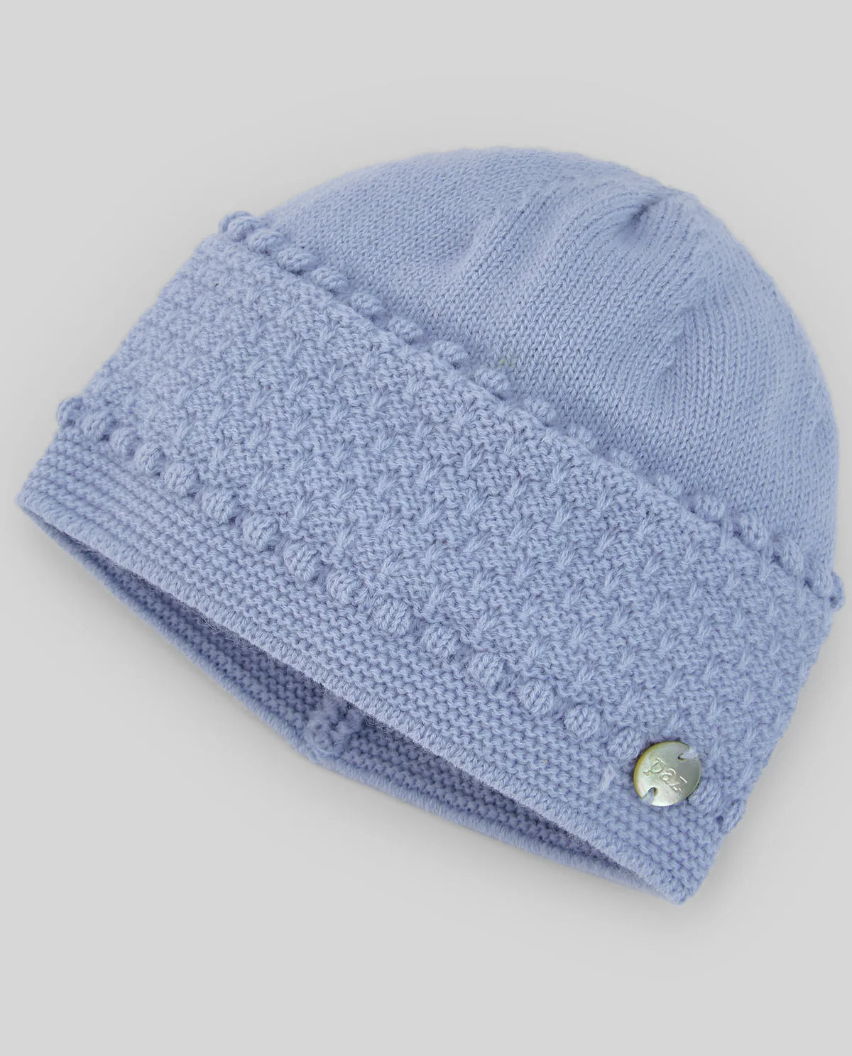 Blue knitted baby hat with a textured pattern on a light gray background