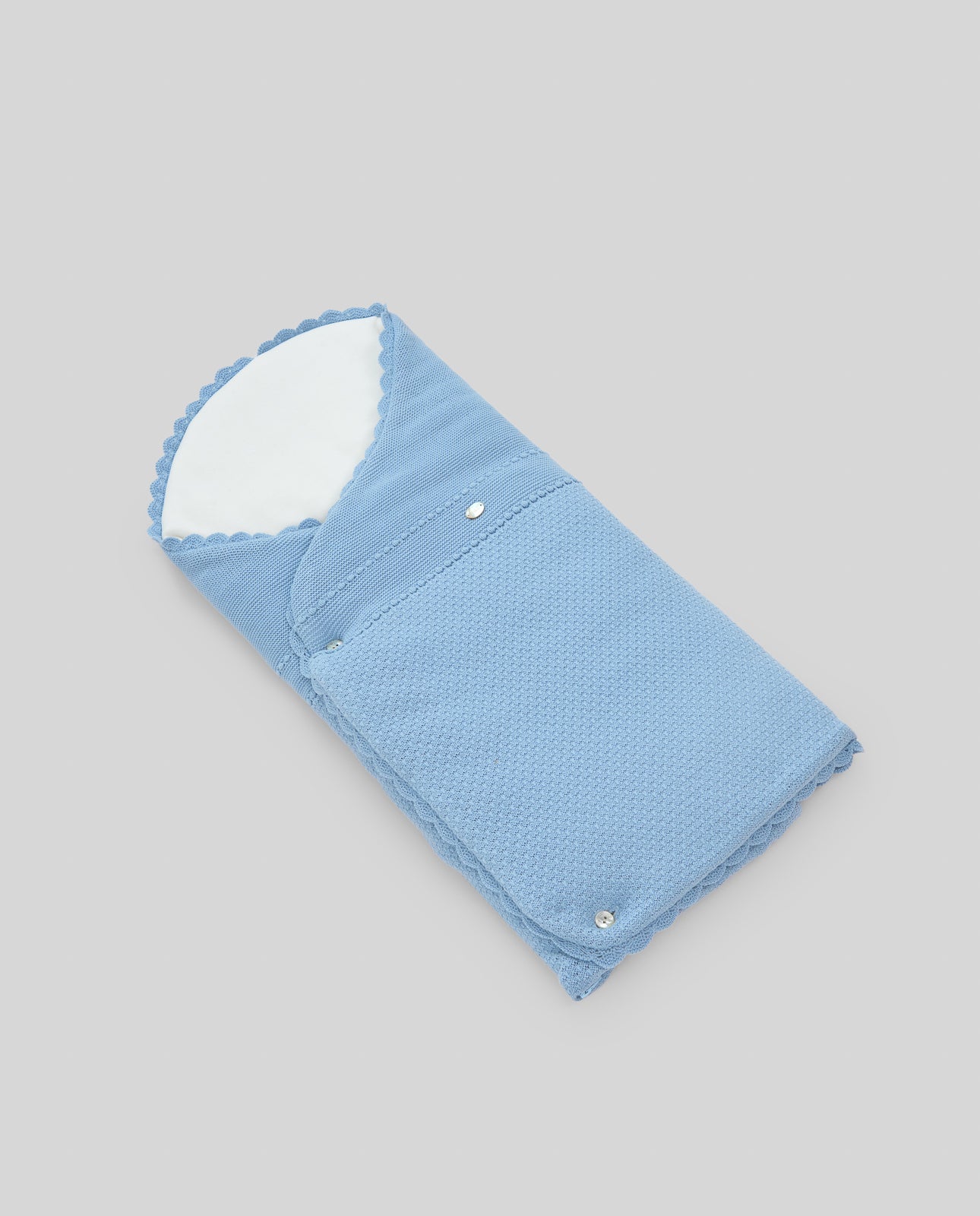Blue baby swaddle with white interior on a gray background
