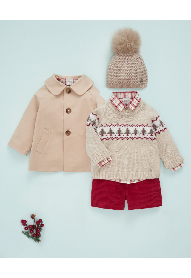 Children's winter clothing set with coat, sweater, shorts, and hat on a light blue background