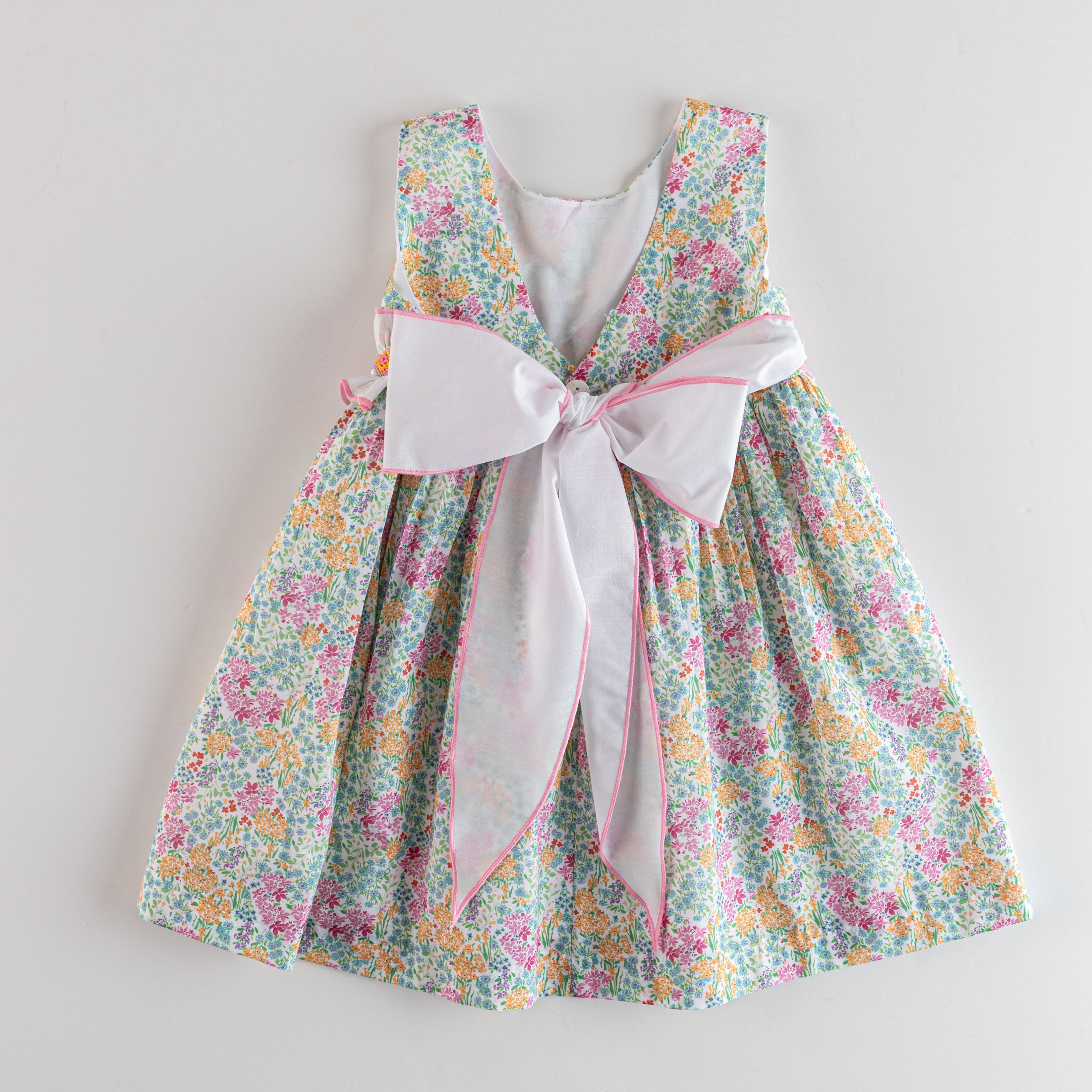 Floral dress with a large bow on a light gray background