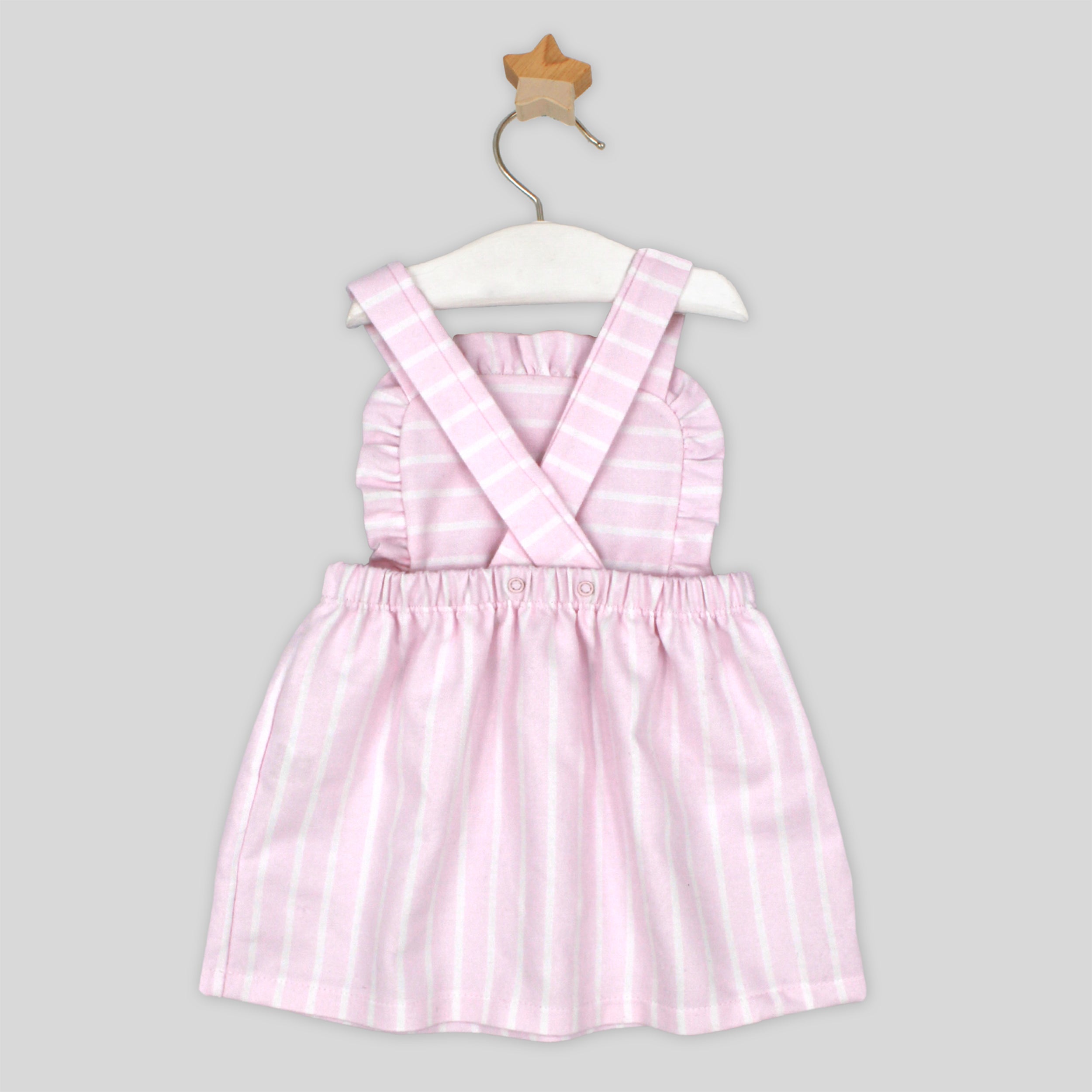 Pink striped dress on a hanger against a gray background