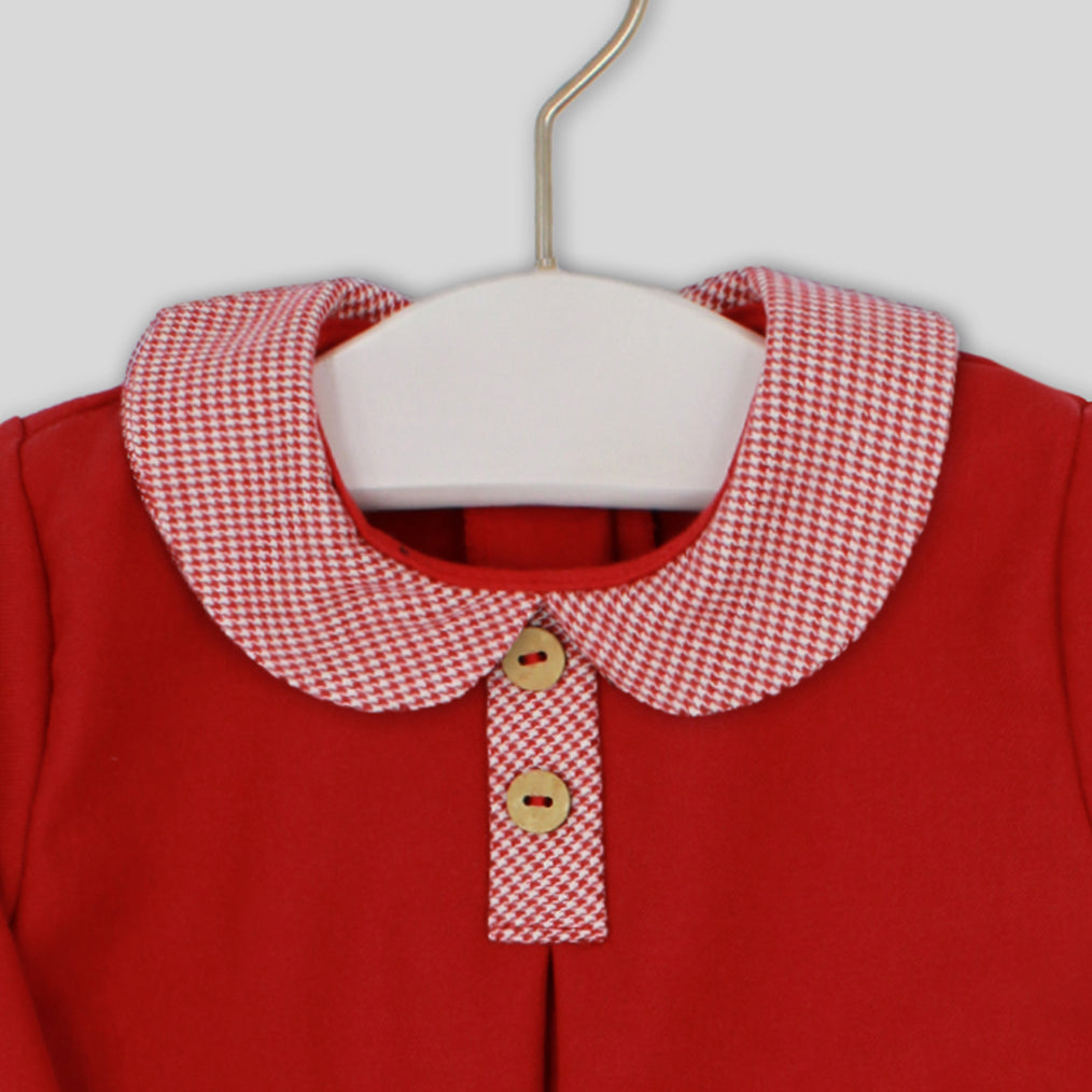Red garment with a checkered collar on a hanger against a white background