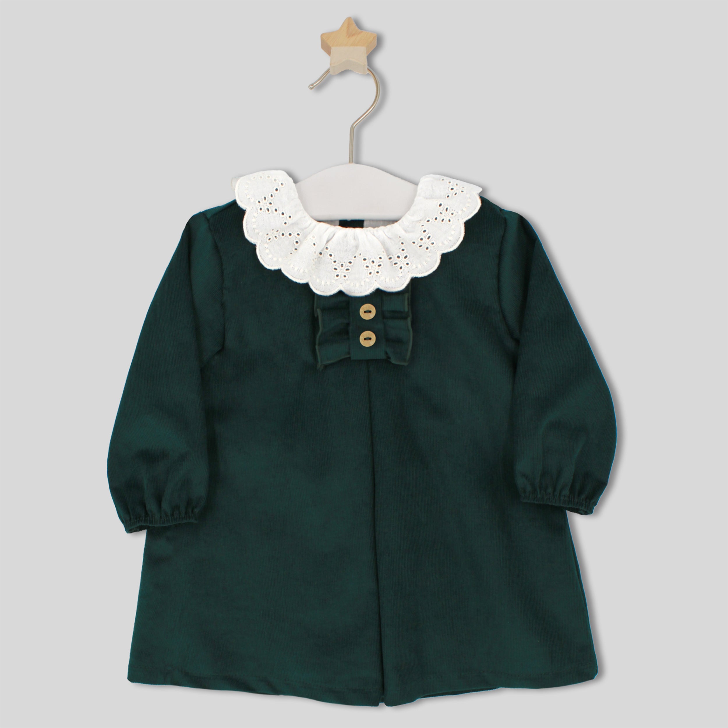 Green dress with white lace collar on a hanger against a gray background