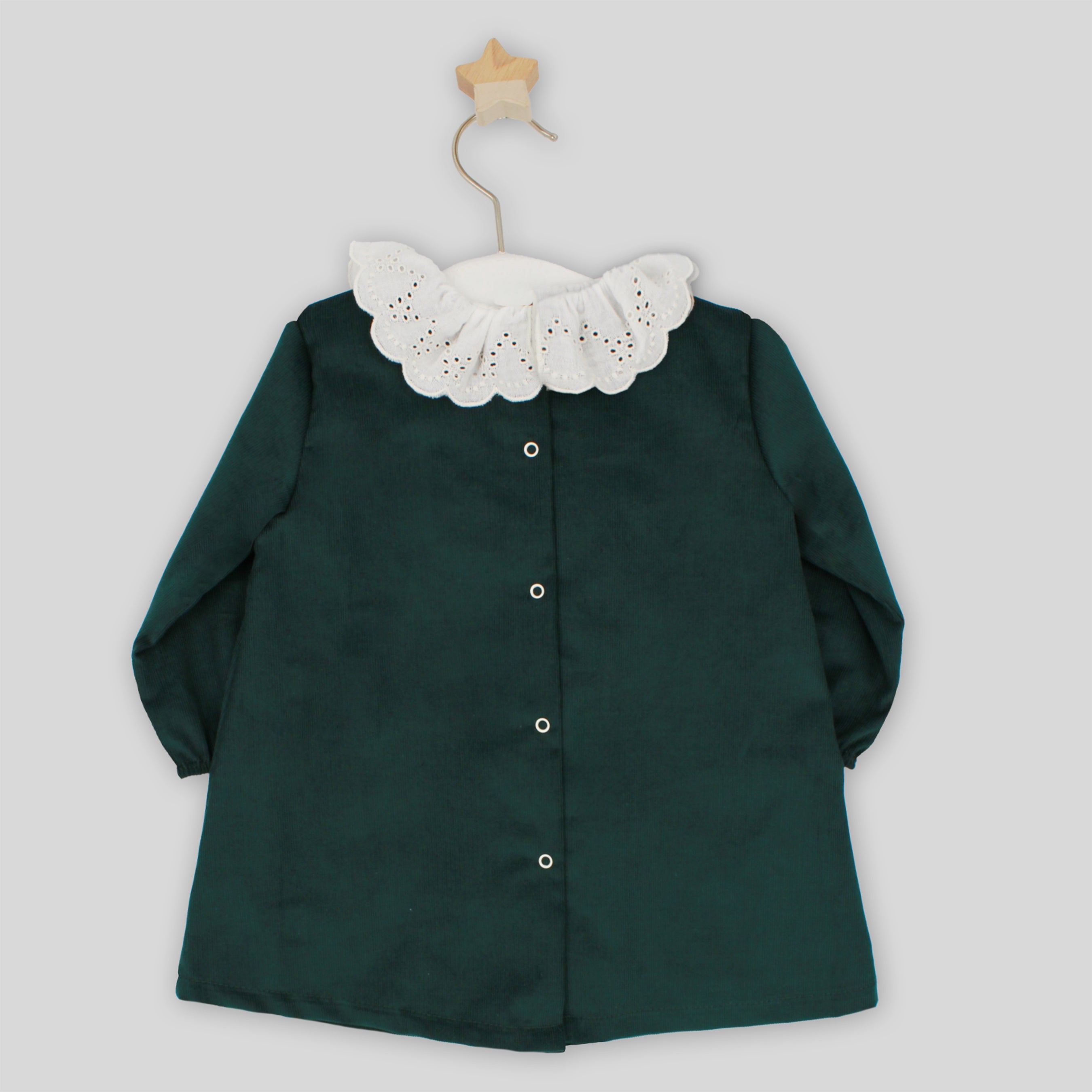 Green shirt with white lace collar on a gray background