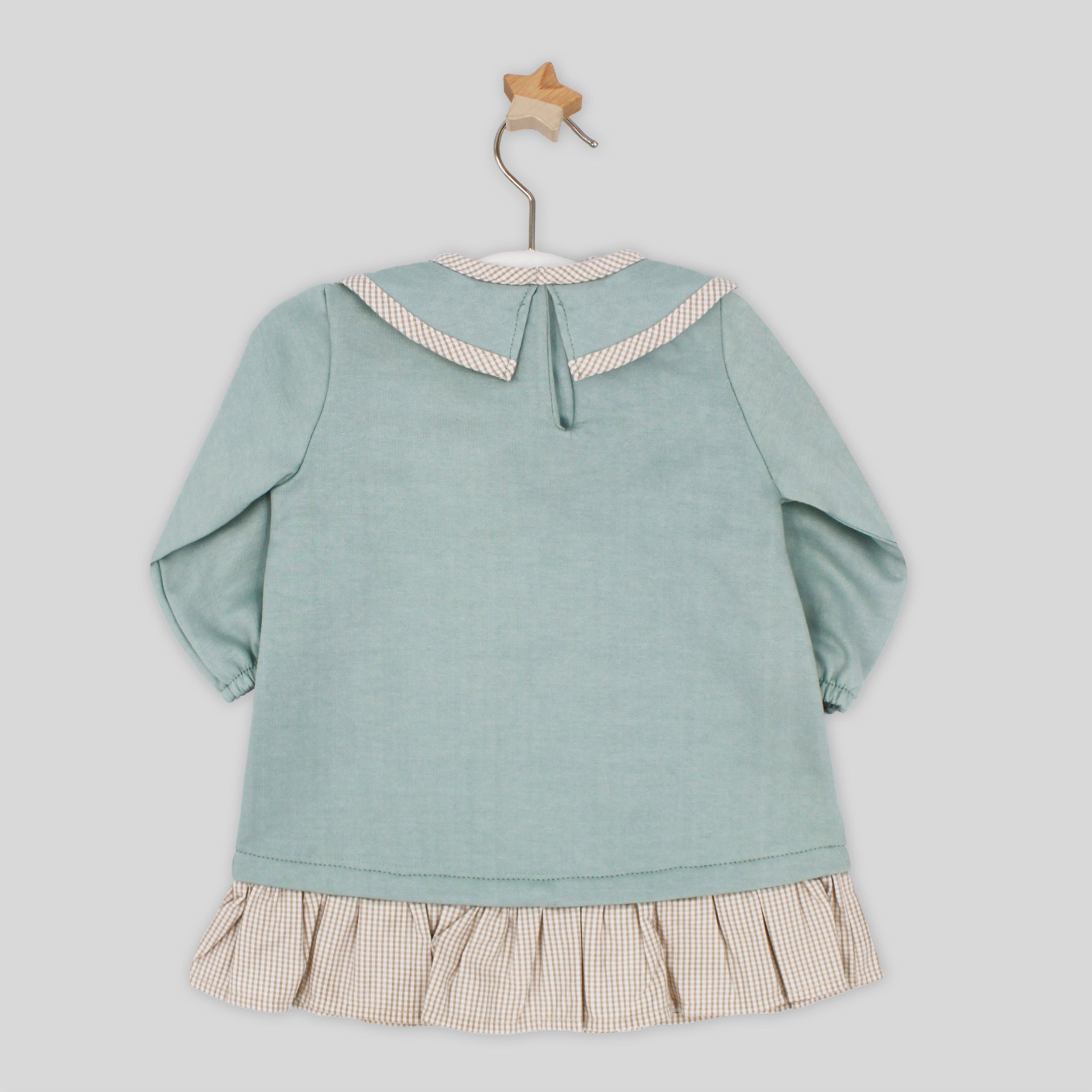 Light blue dress with a checkered skirt on a hanger against a light gray background