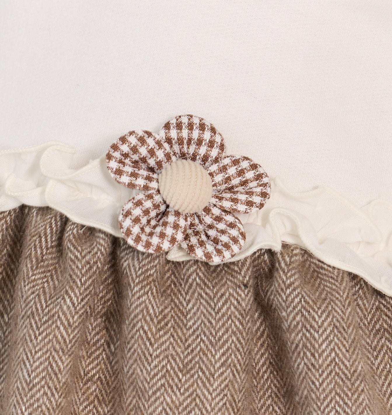 Brown herringbone fabric with a checkered flower detail on a white background