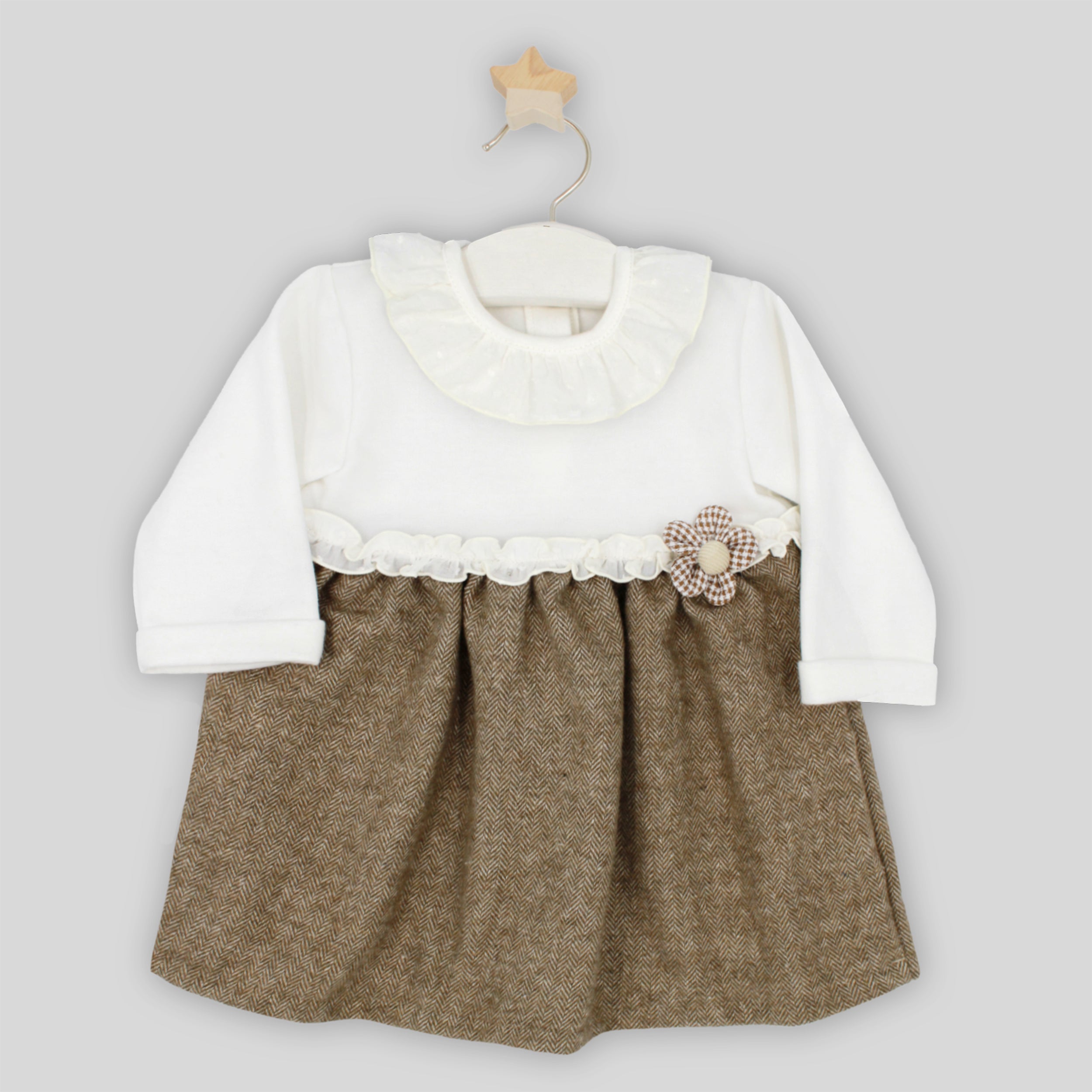 Baby dress with white top and brown skirt on a hanger against a light gray background