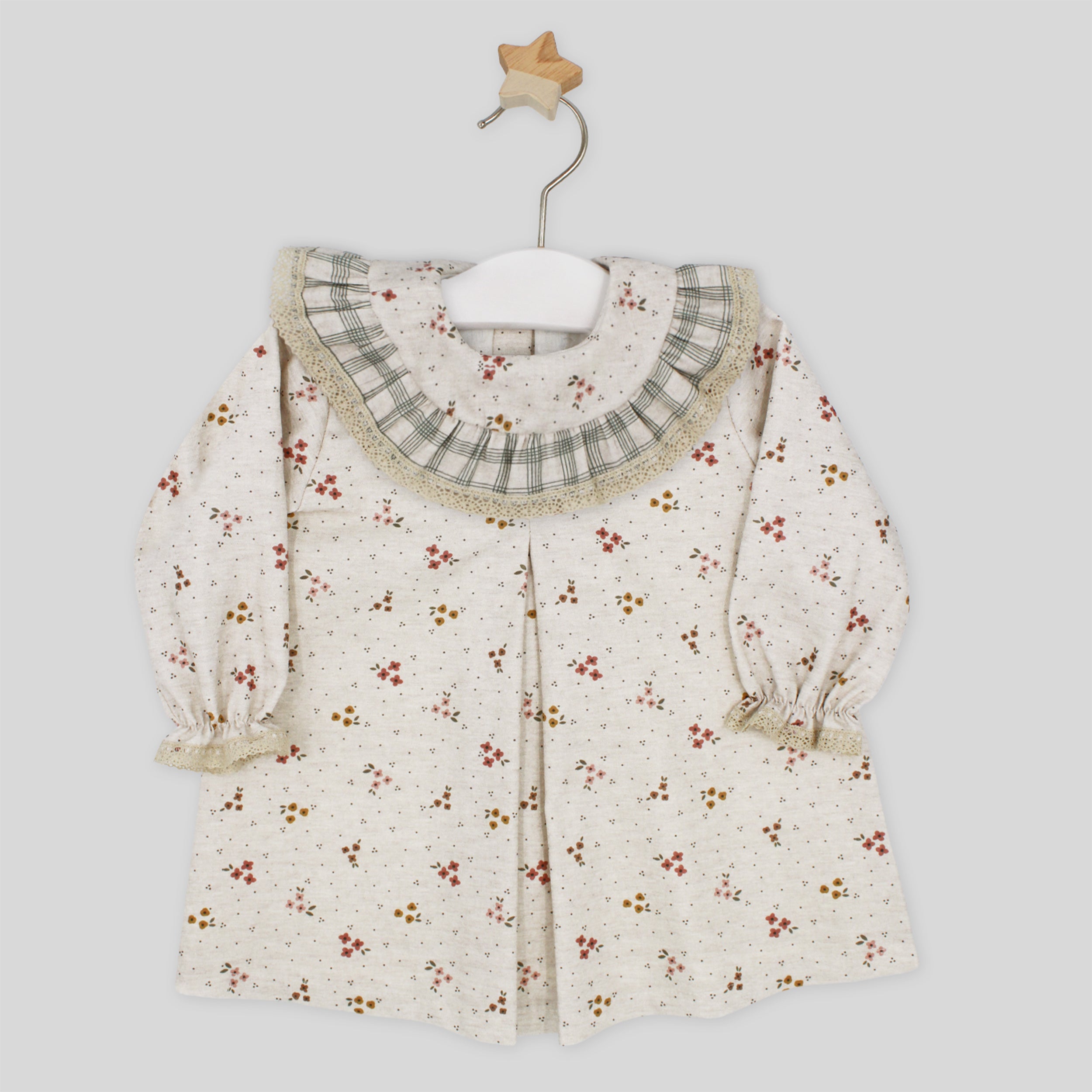 Floral-patterned baby dress with a ruffled collar on a white background