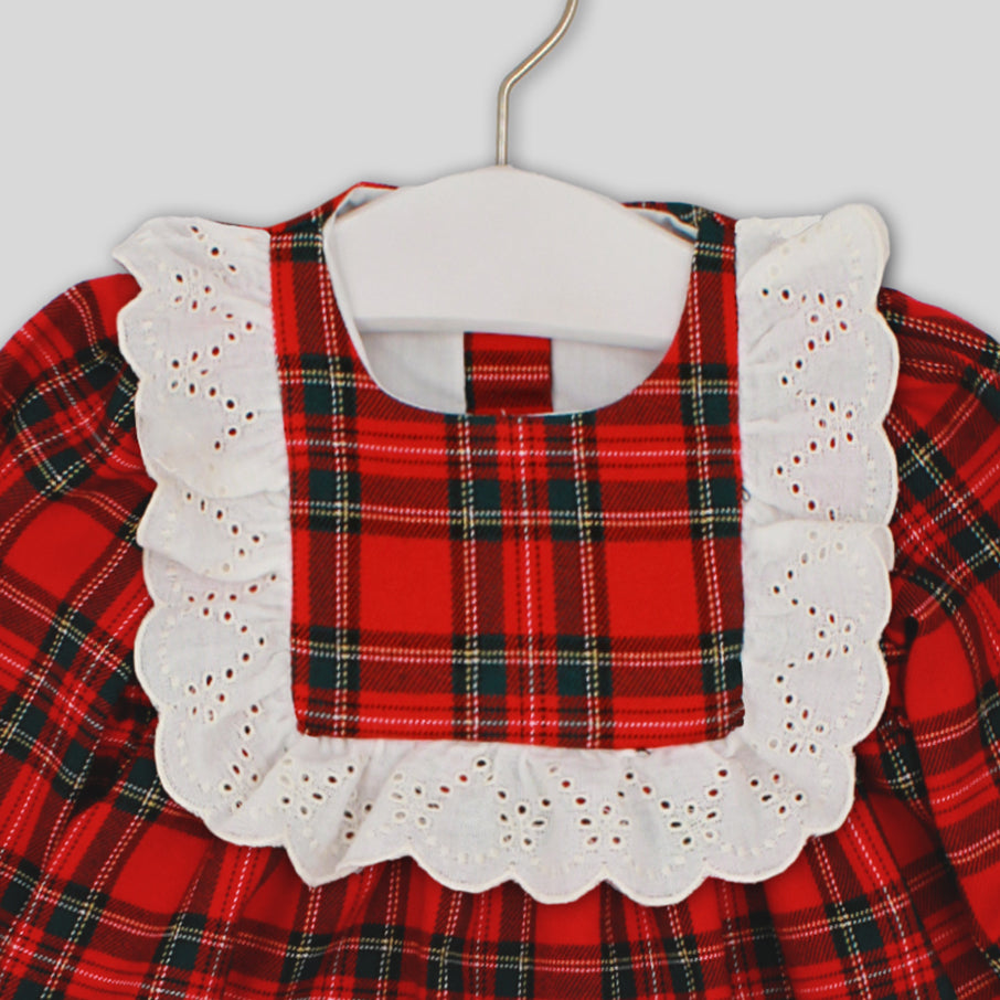 Red plaid dress with white lace collar on a hanger against a light background
