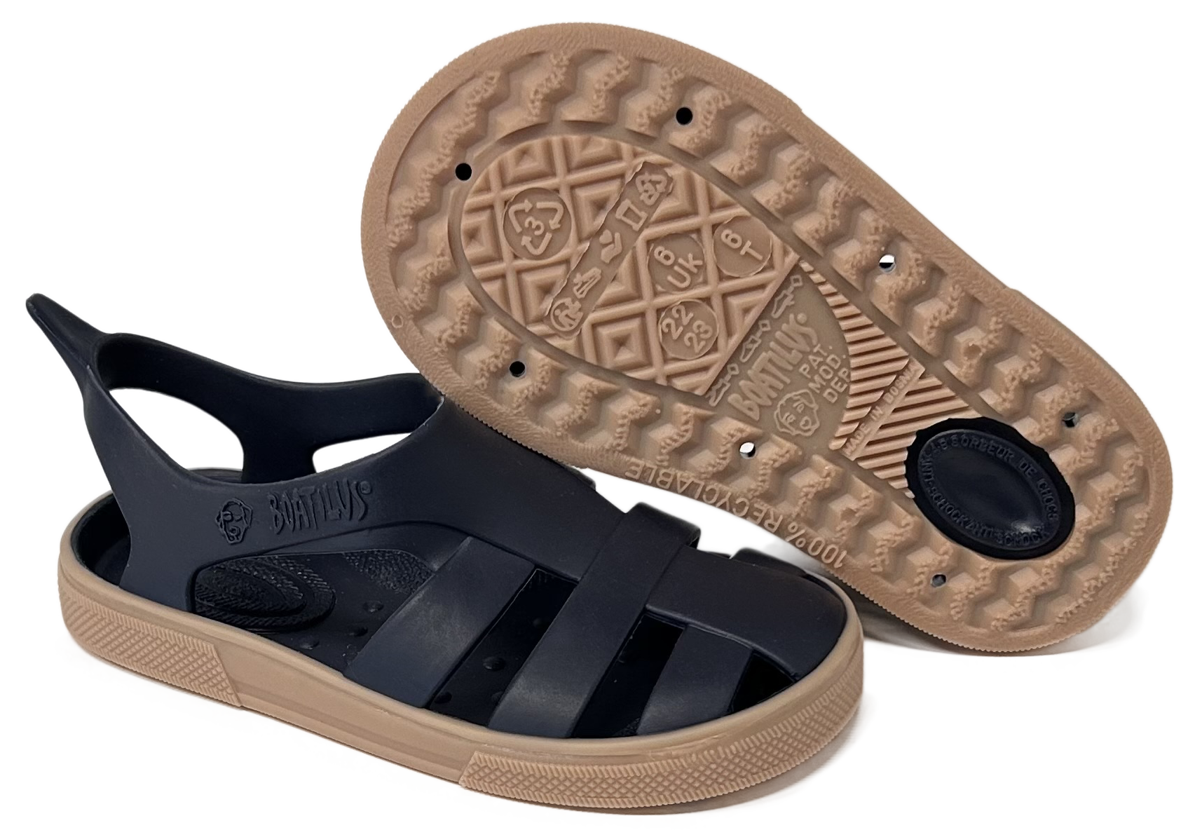 Black sandal with tan sole on a white background