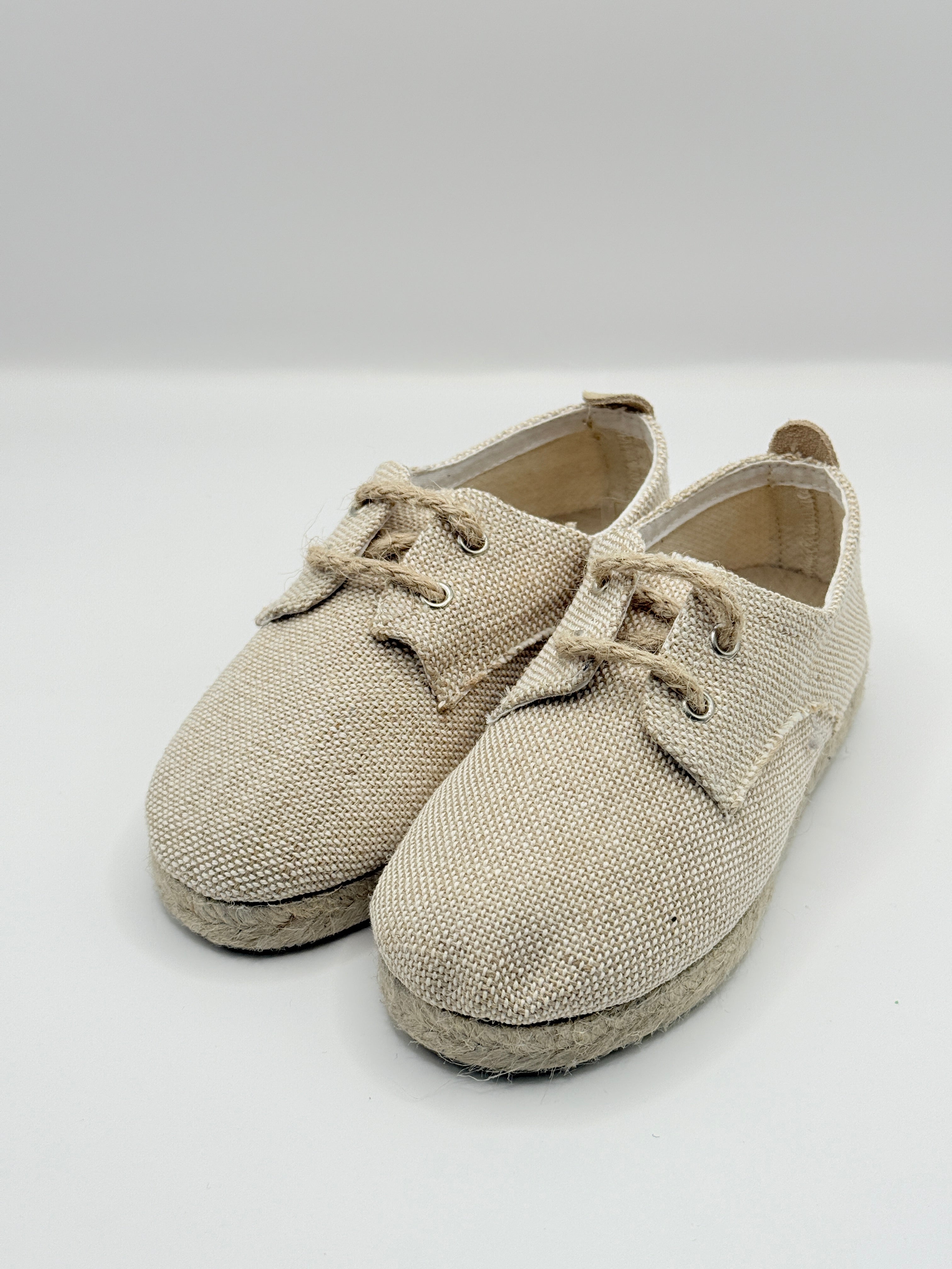 Pair of beige baby shoes on a white background