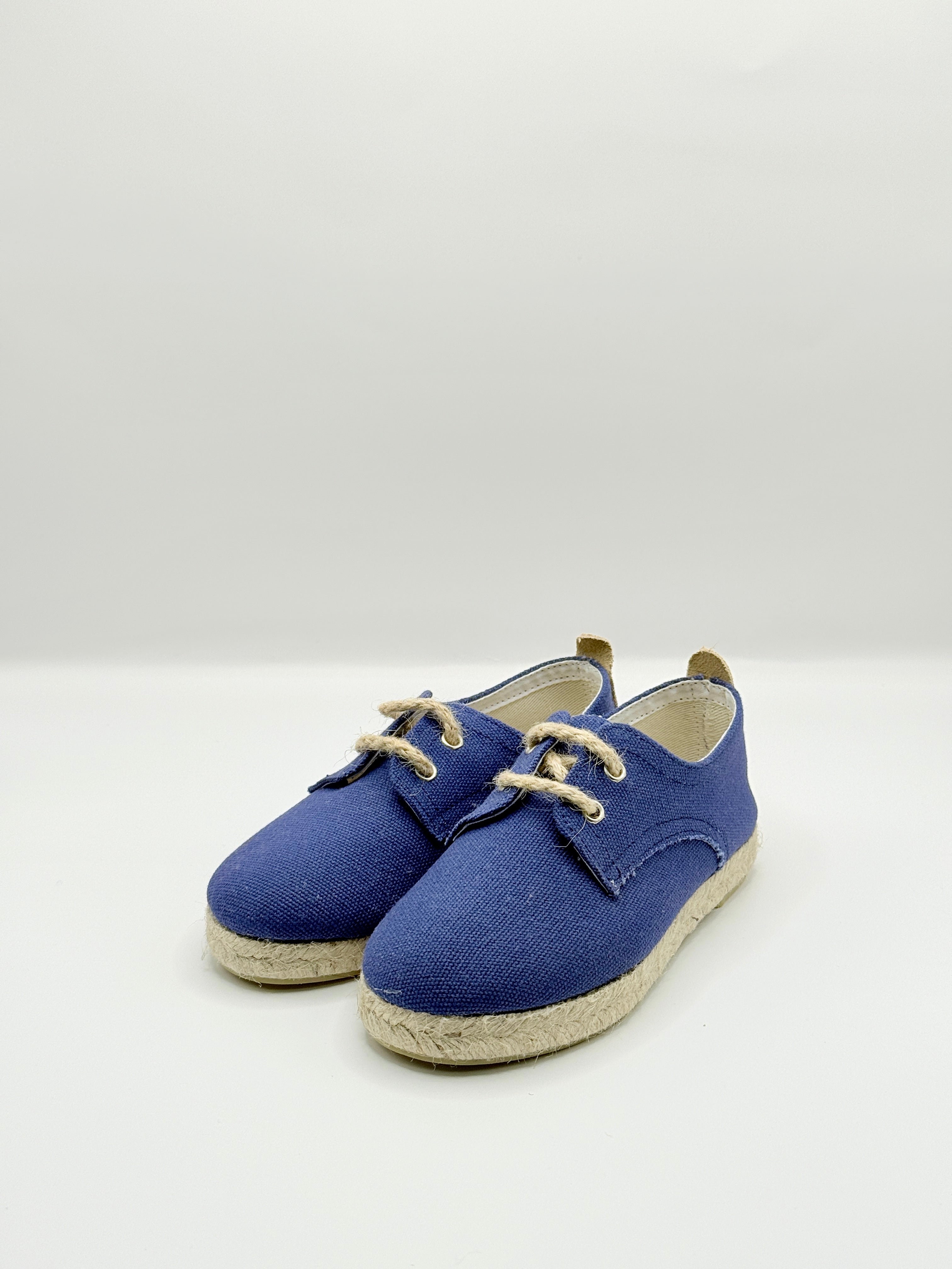Pair of blue espadrilles with jute soles on a white background