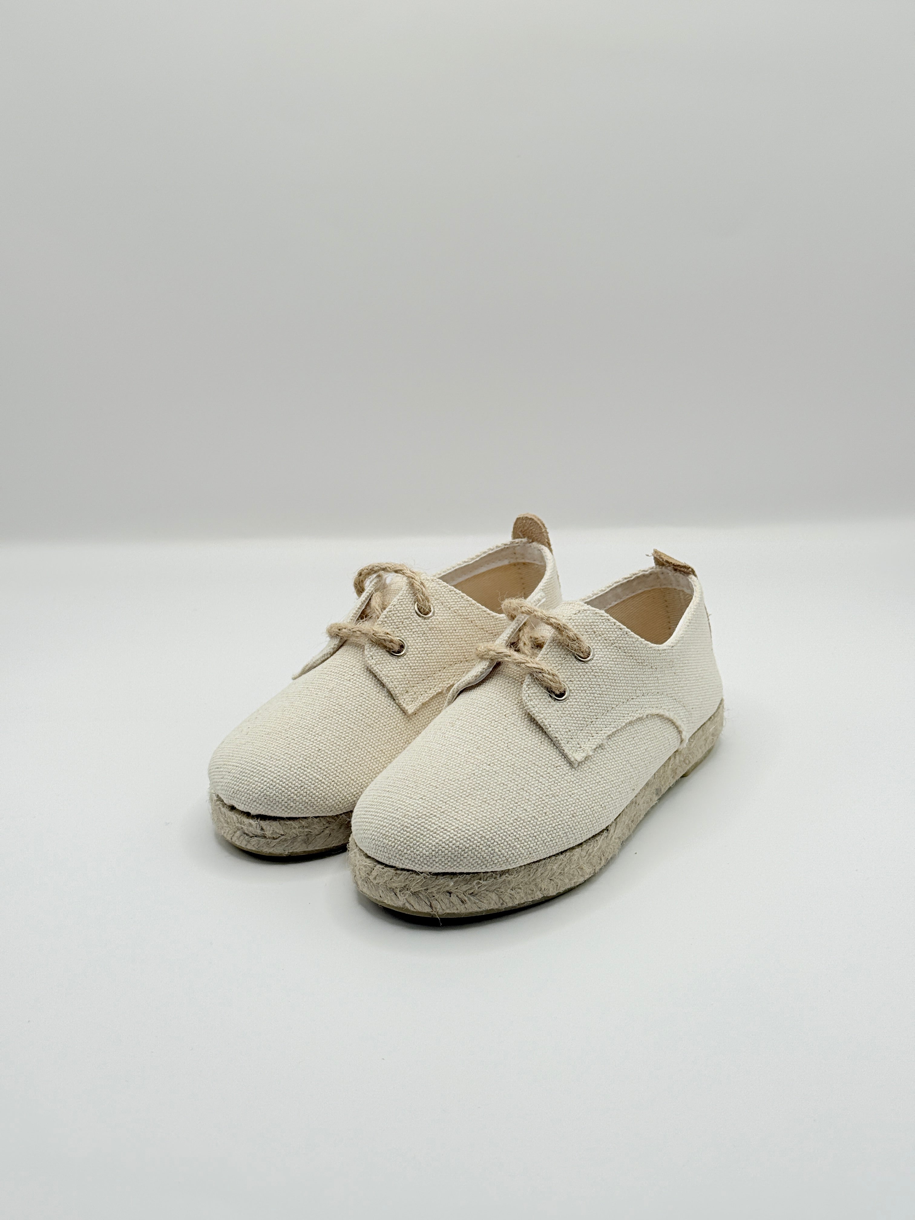 Pair of beige shoes on a white background