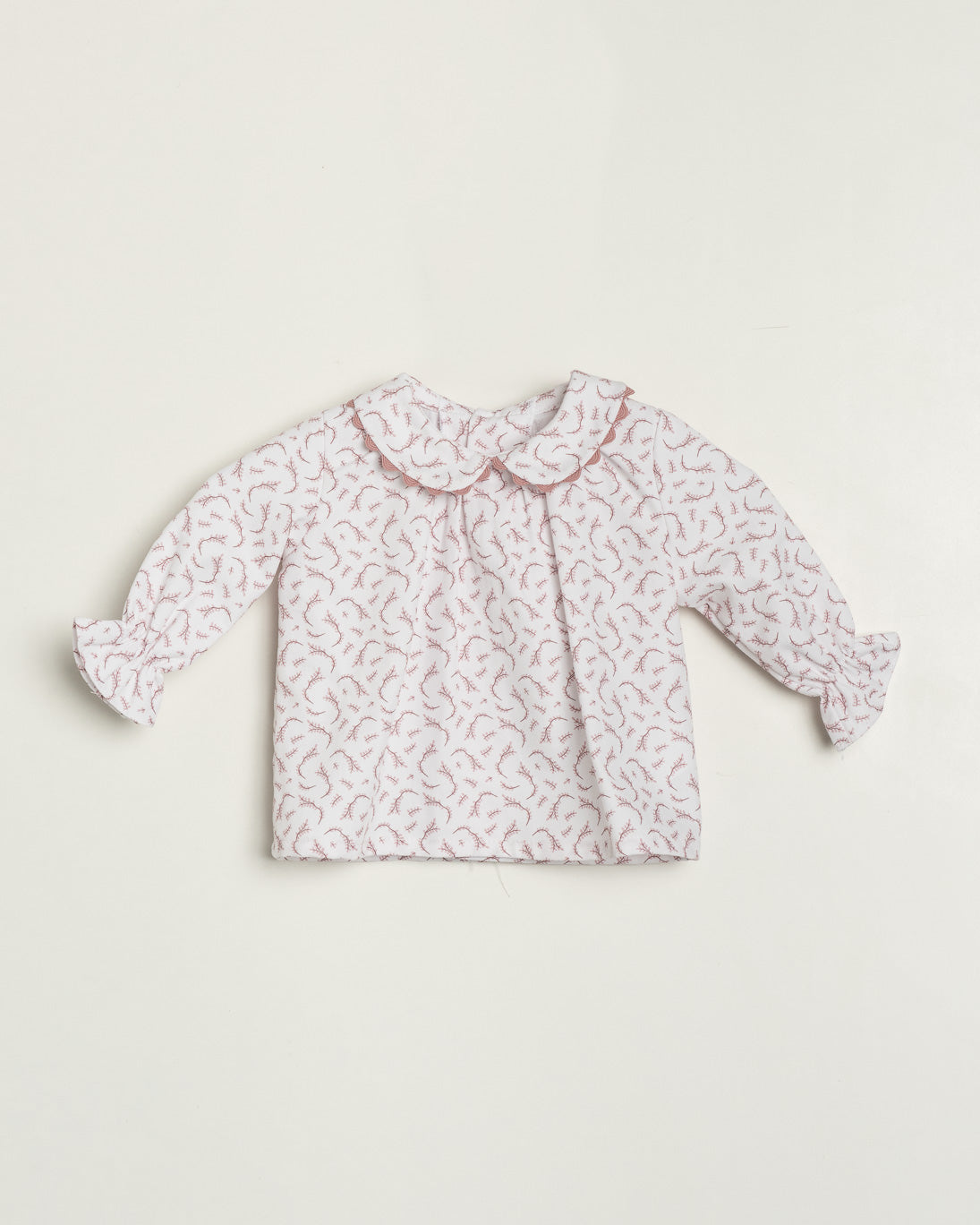 Baby blouse with floral pattern on a white background