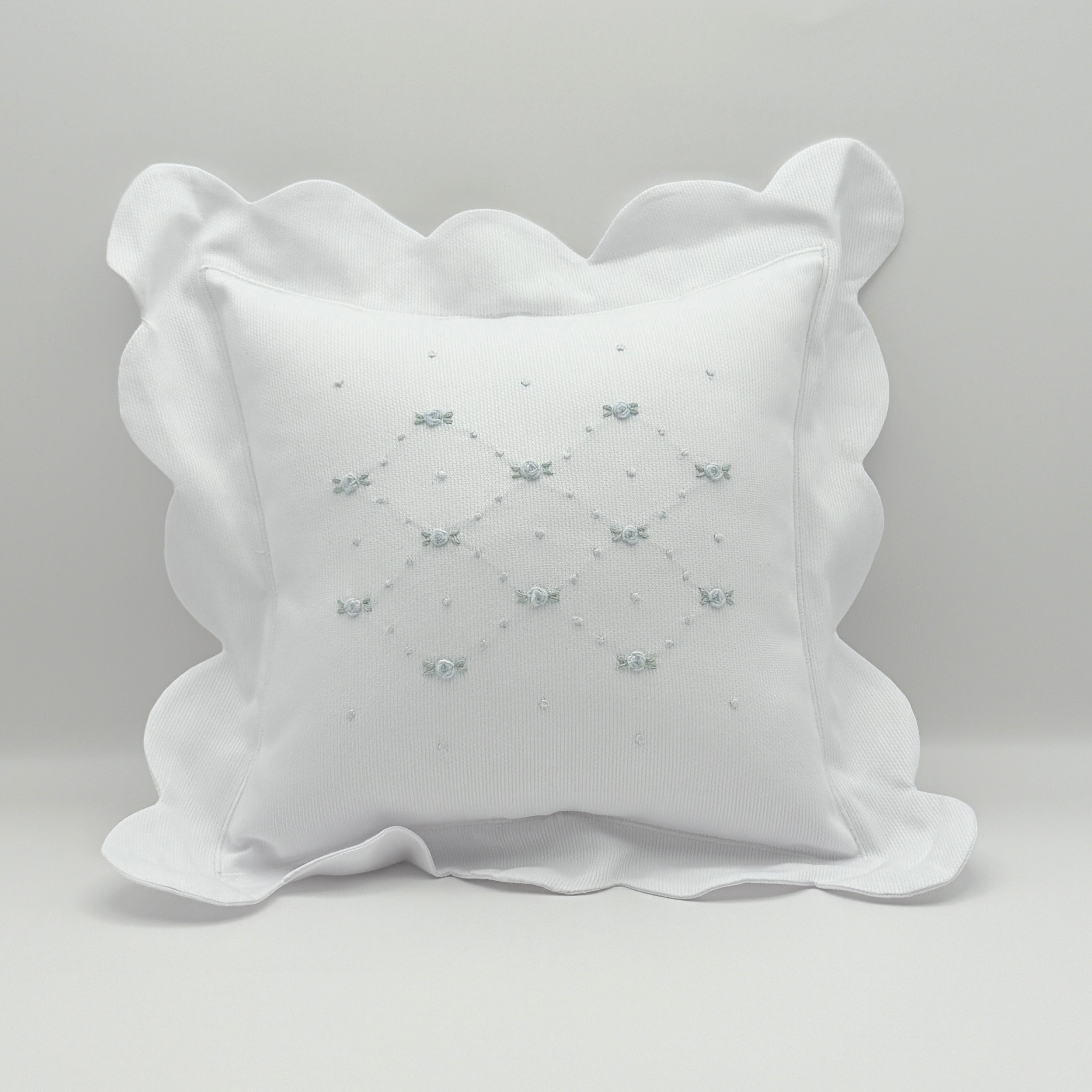 Decorative pillow with scalloped edge on a light gray background