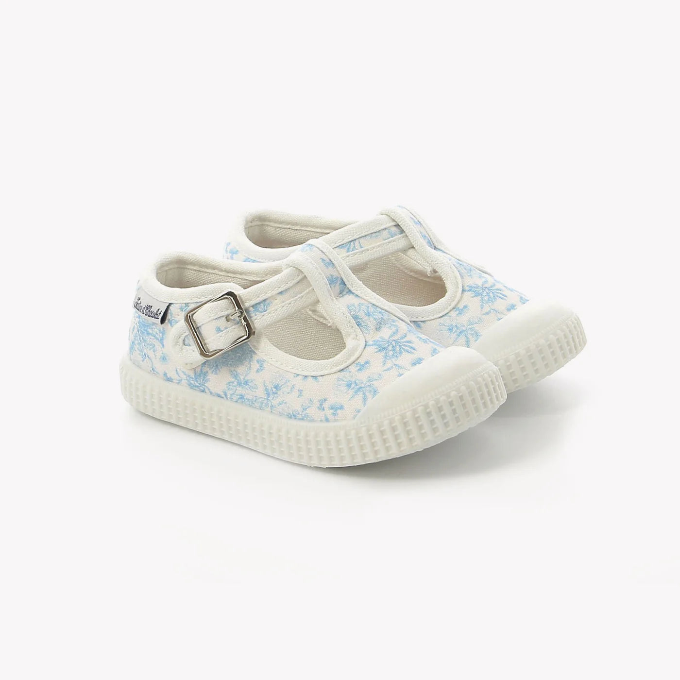 Pair of children's shoes with floral pattern on a white background