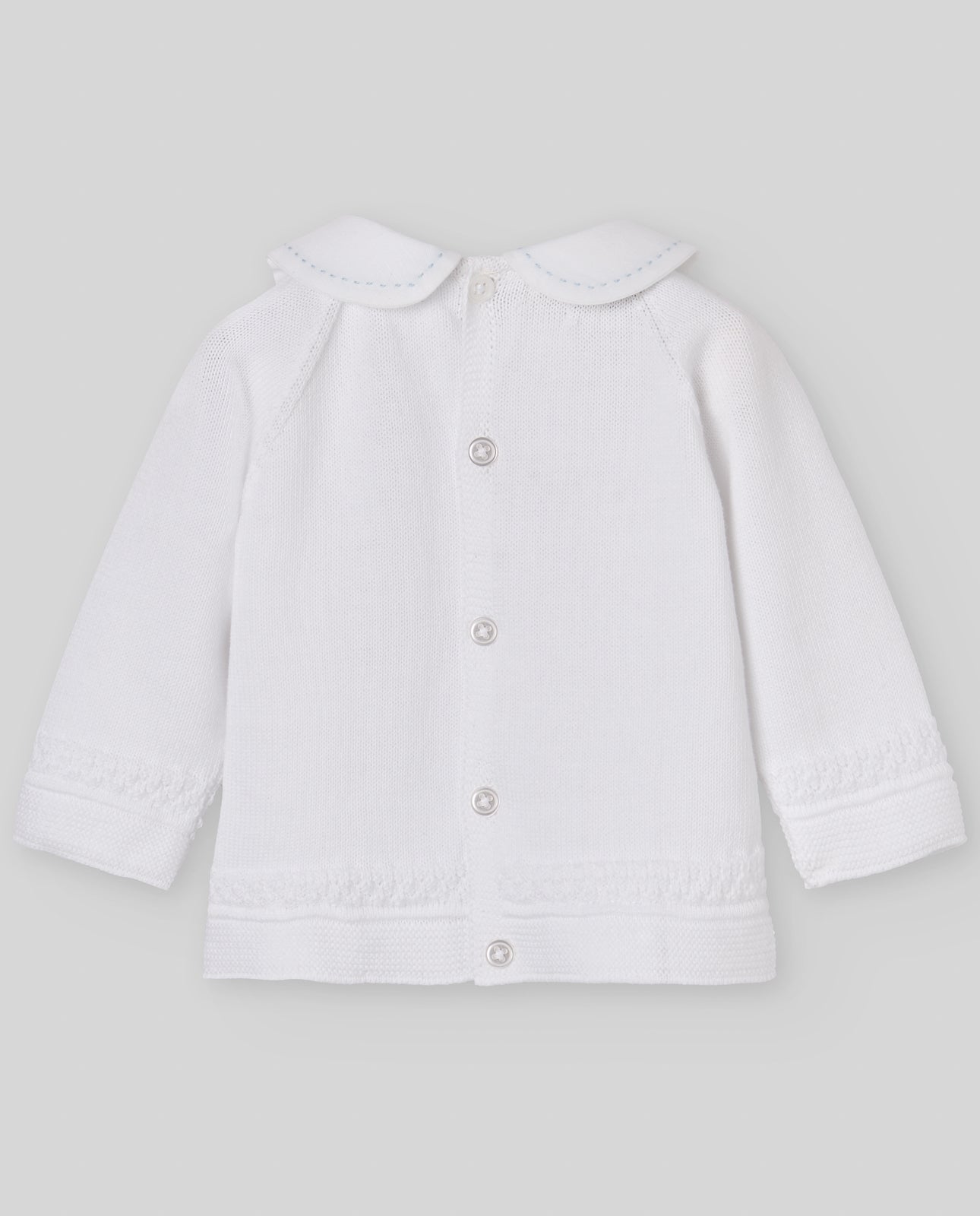 White baby jacket with buttons on a light gray background