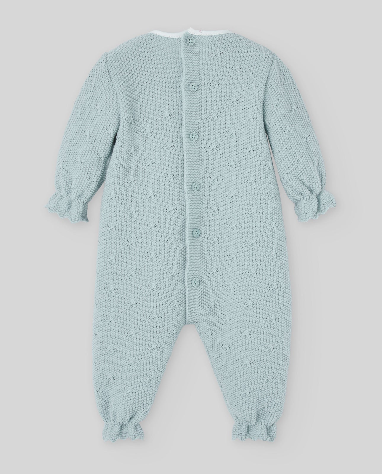 Light blue knitted baby romper with star pattern on a light gray background