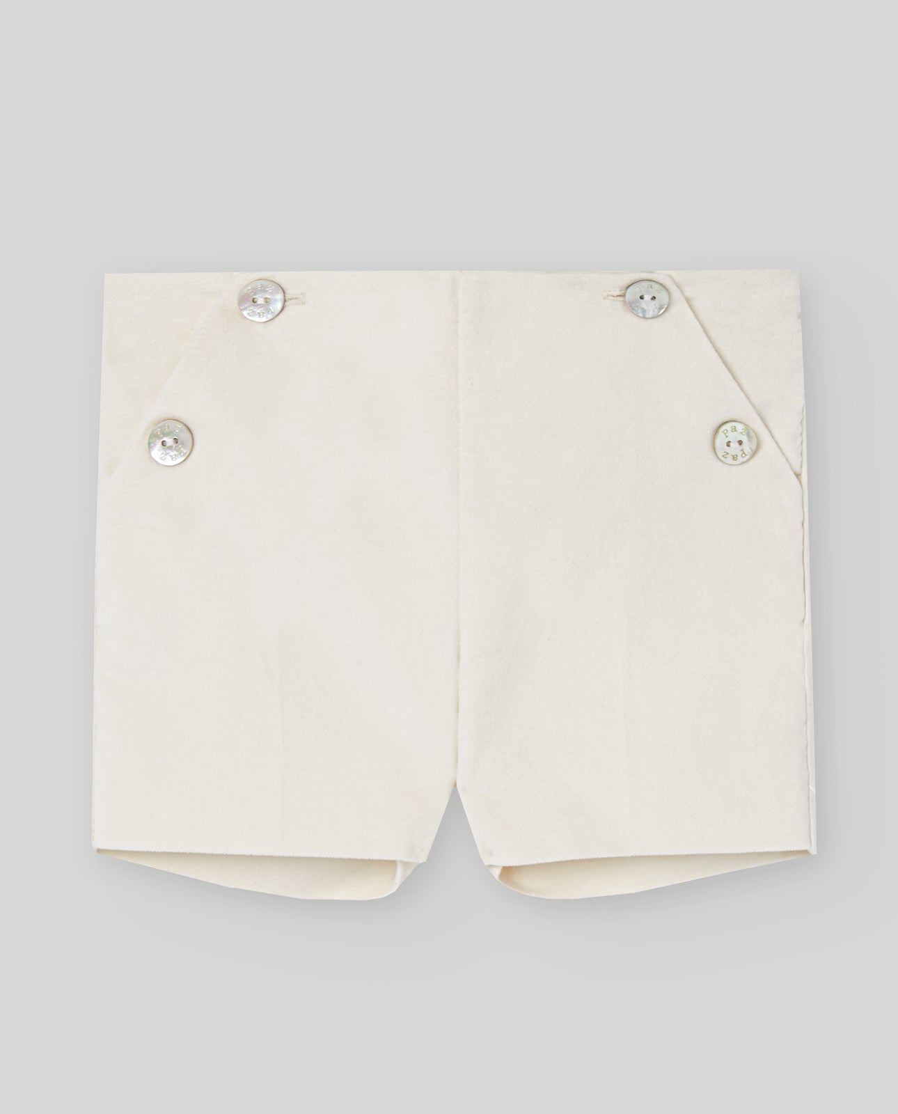 White shorts with button details on a light gray background