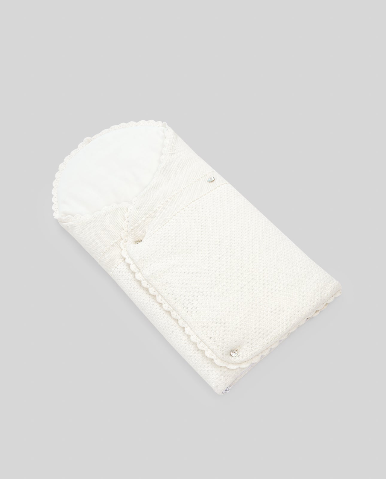 White folded baby nest on a gray background