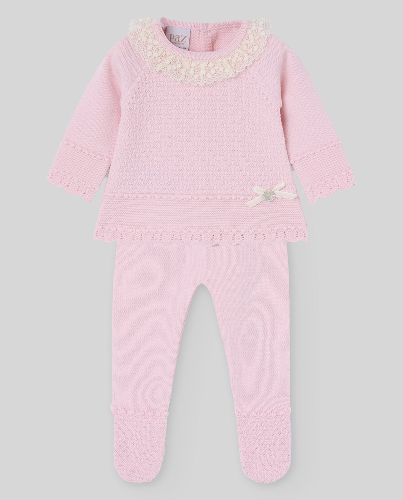 Pink baby outfit with lace details on a gray background