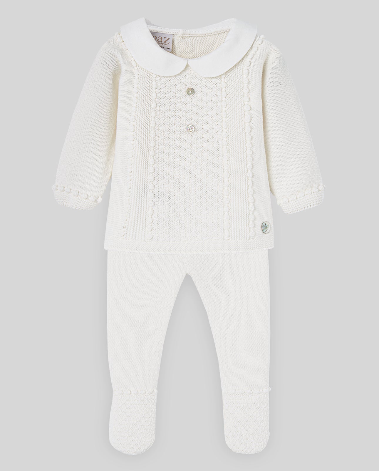 White baby knitted outfit with a collar on a light gray background