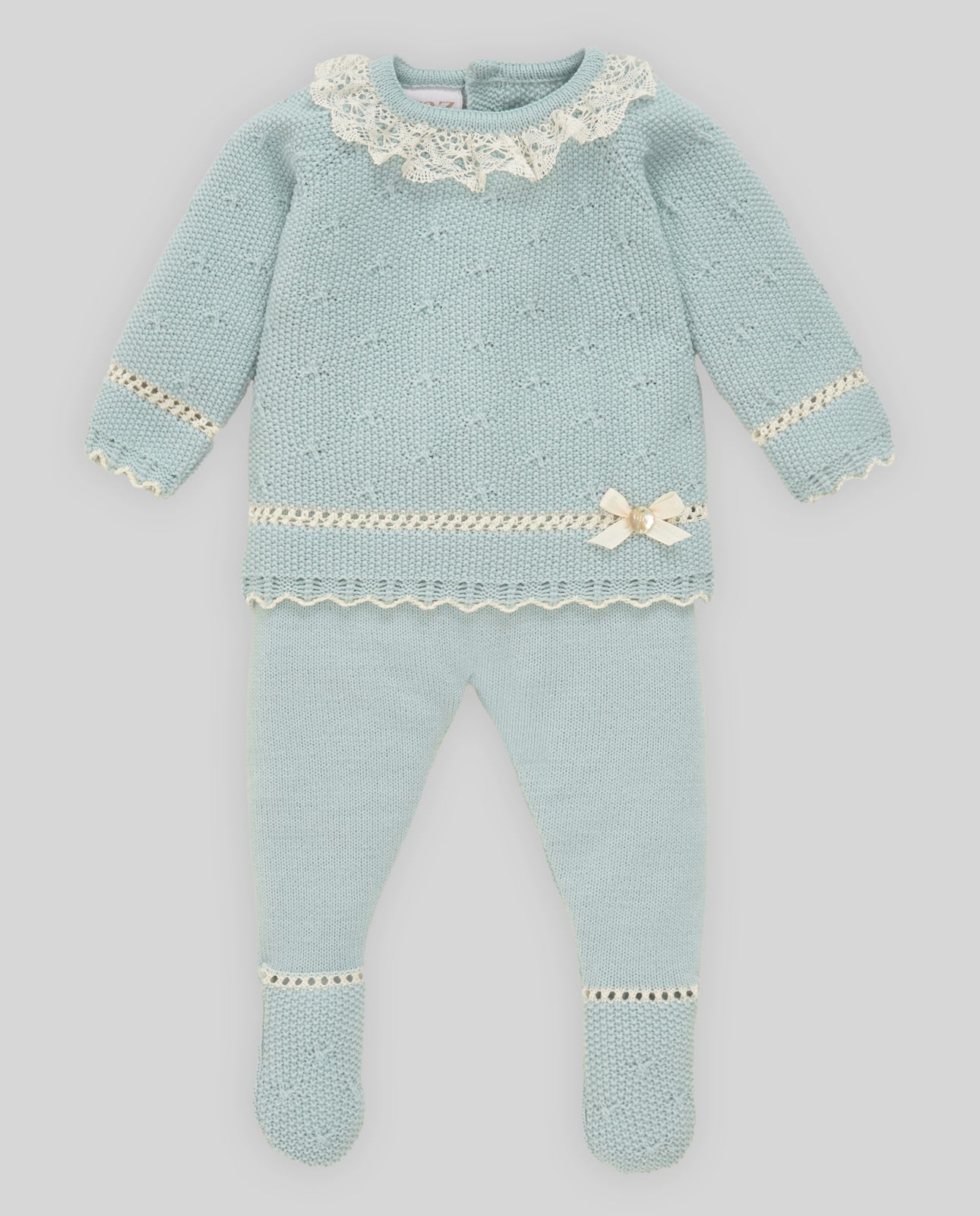 Knitted baby outfit with lace details on a light gray background
