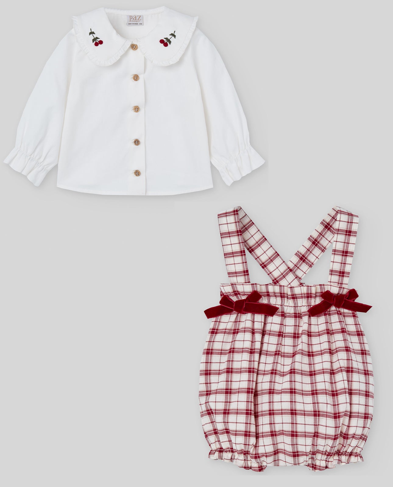 White blouse with cherry details and red plaid romper on a light gray background