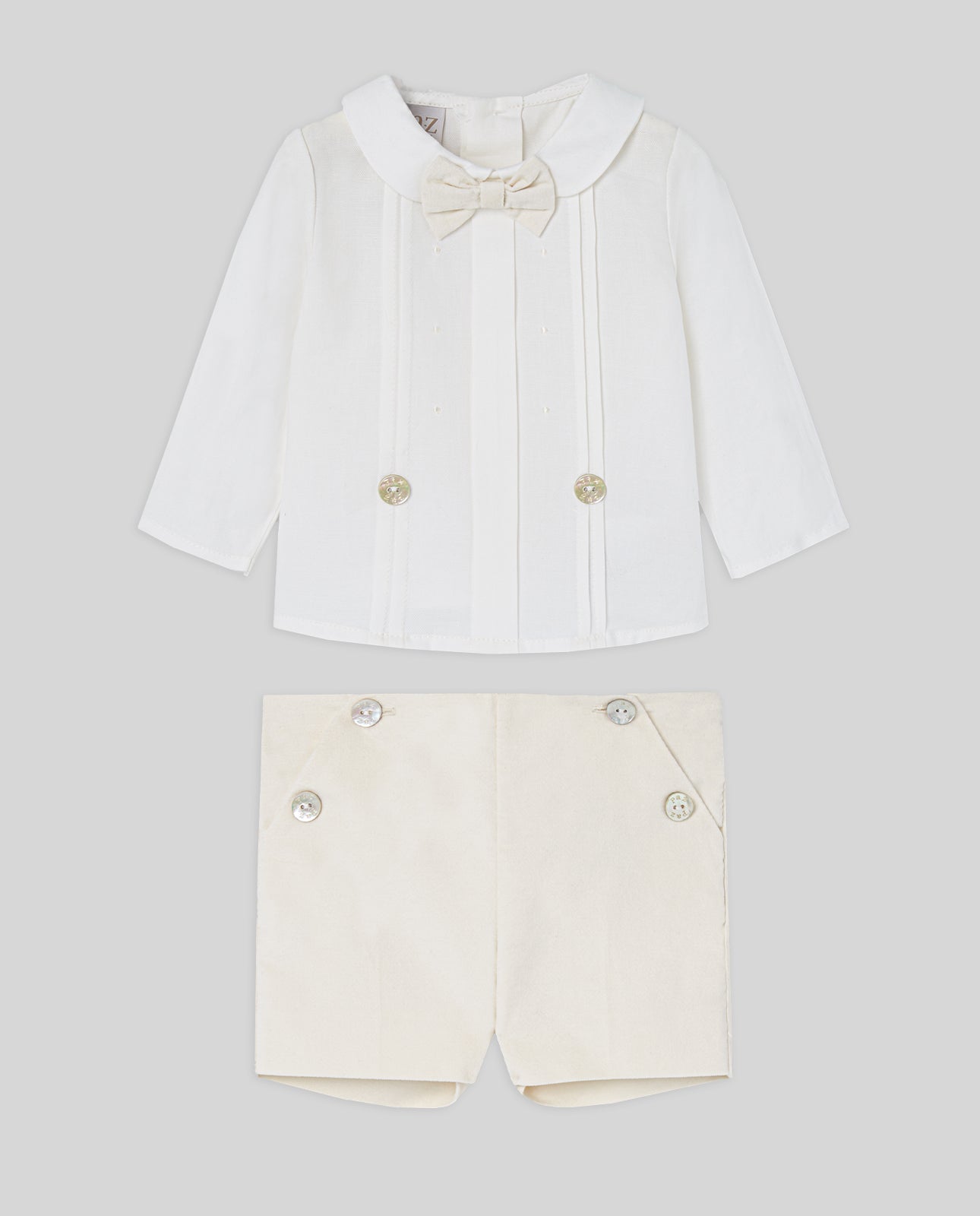White shirt with bow tie and shorts on a light gray background