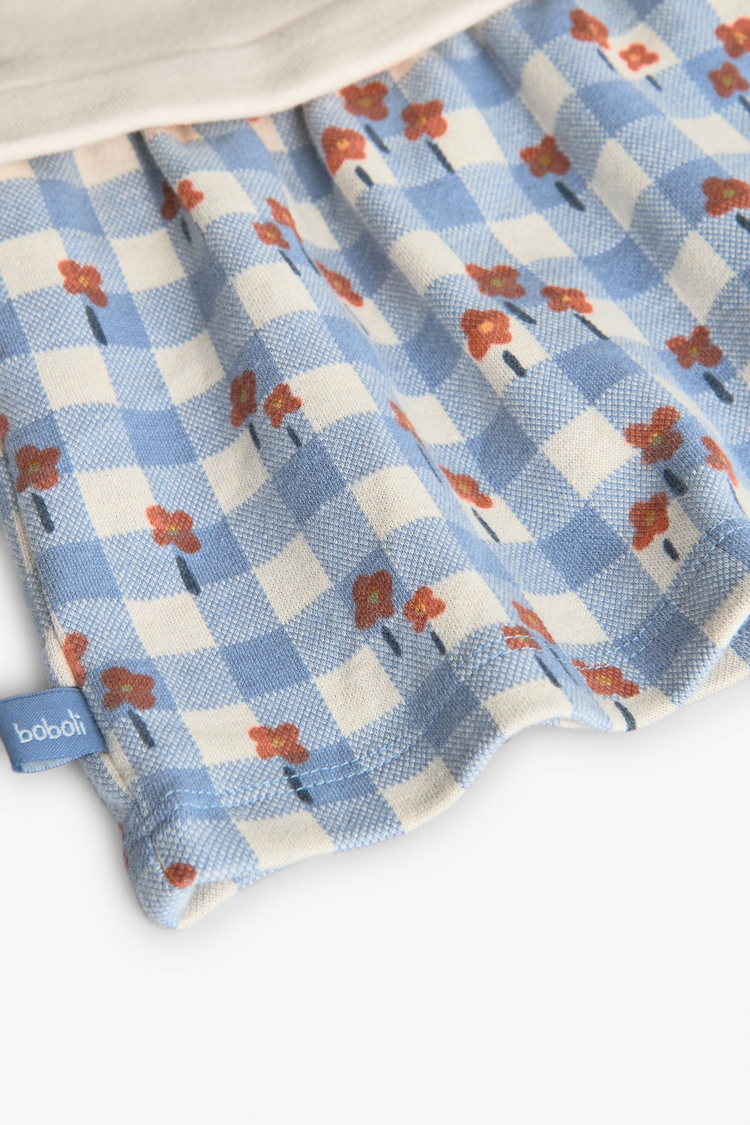 Fabric with blue checkered pattern and red floral design, featuring the brand 'Bubba'.