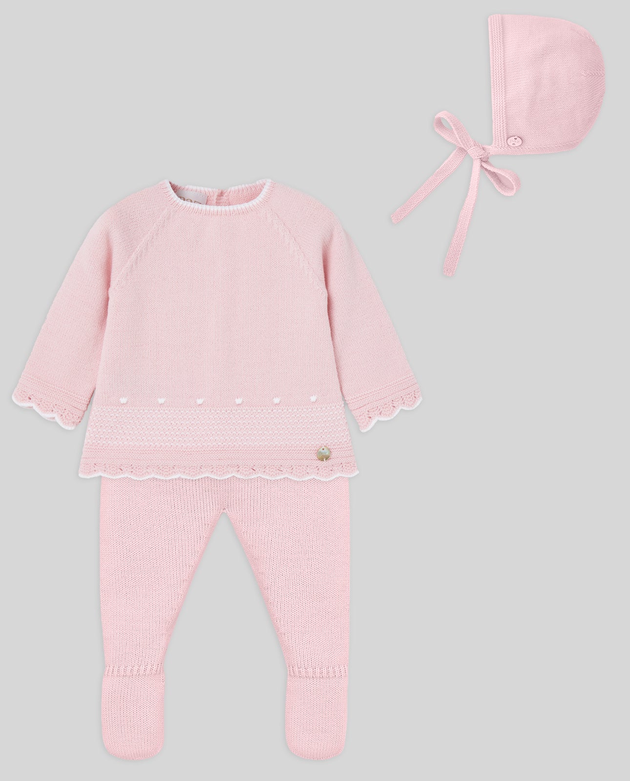 Pink baby outfit with top, pants, and hat on a gray background
