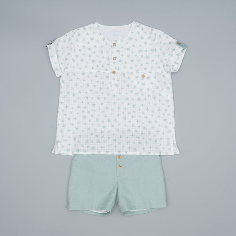 Children's outfit with a patterned shirt and light green shorts on a gray background