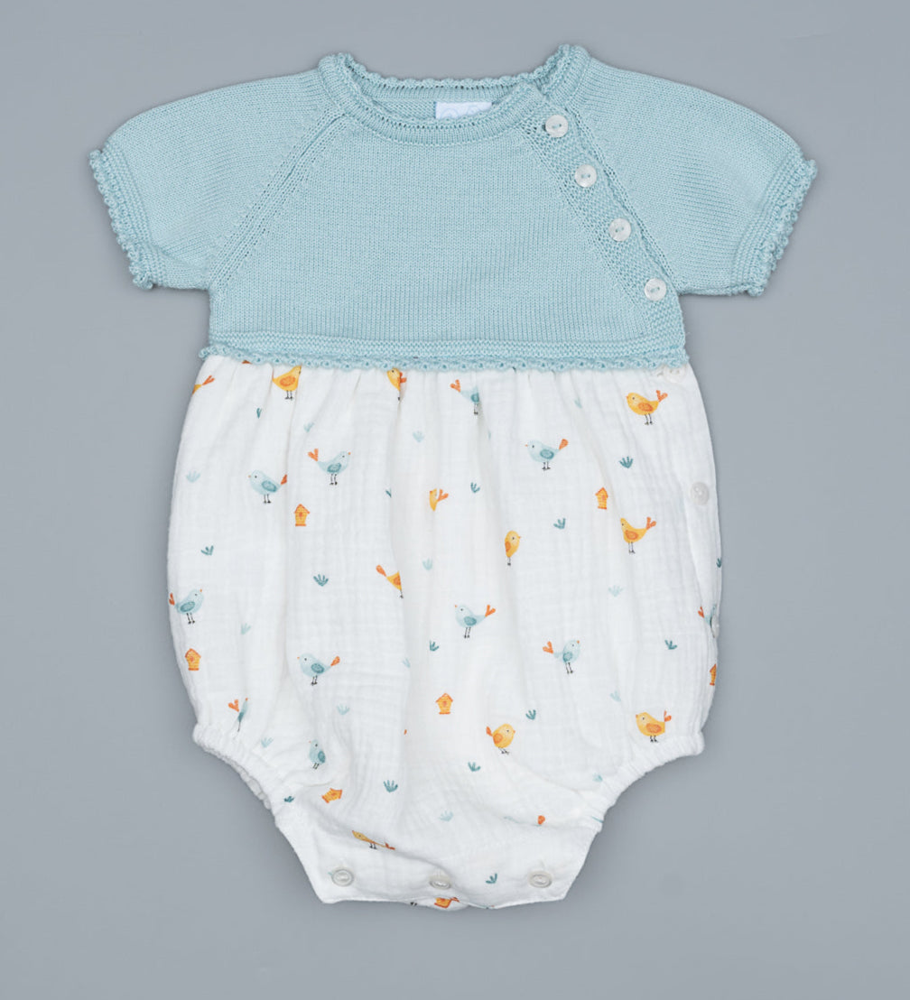 Baby romper with light mint top and white bottom with animal pattern on a white background.