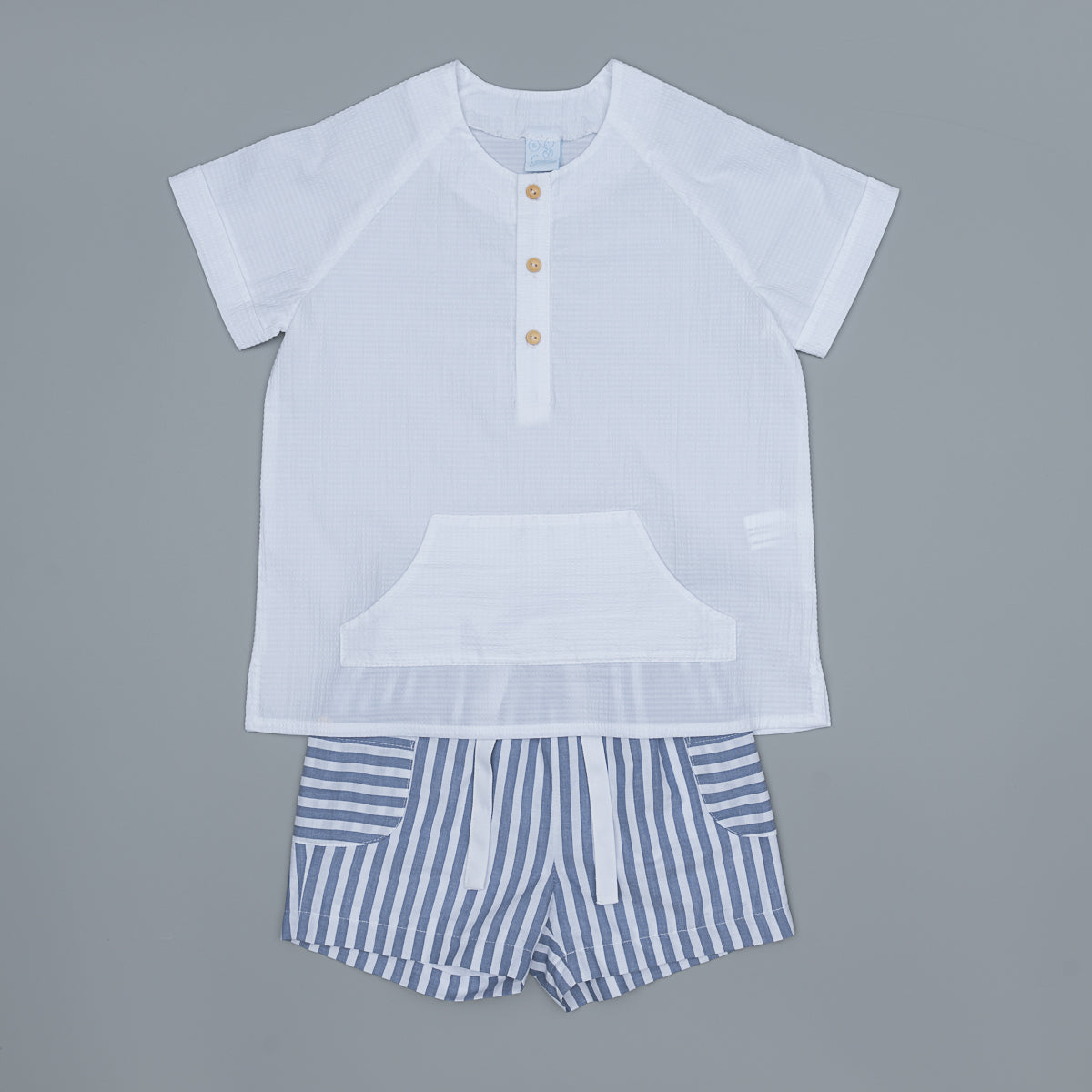 White shirt with buttons and striped shorts on a gray background