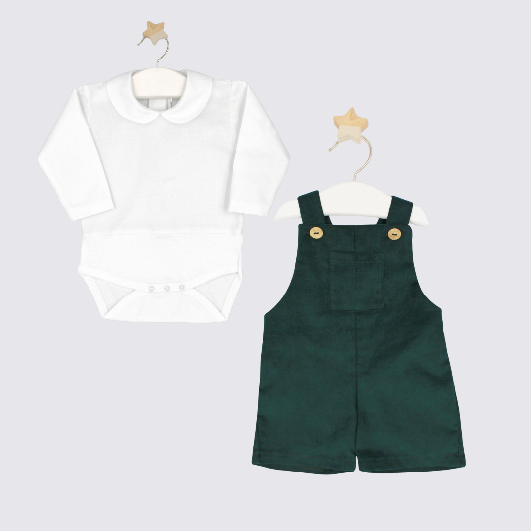 White shirt and green overalls on hangers against a light gray background