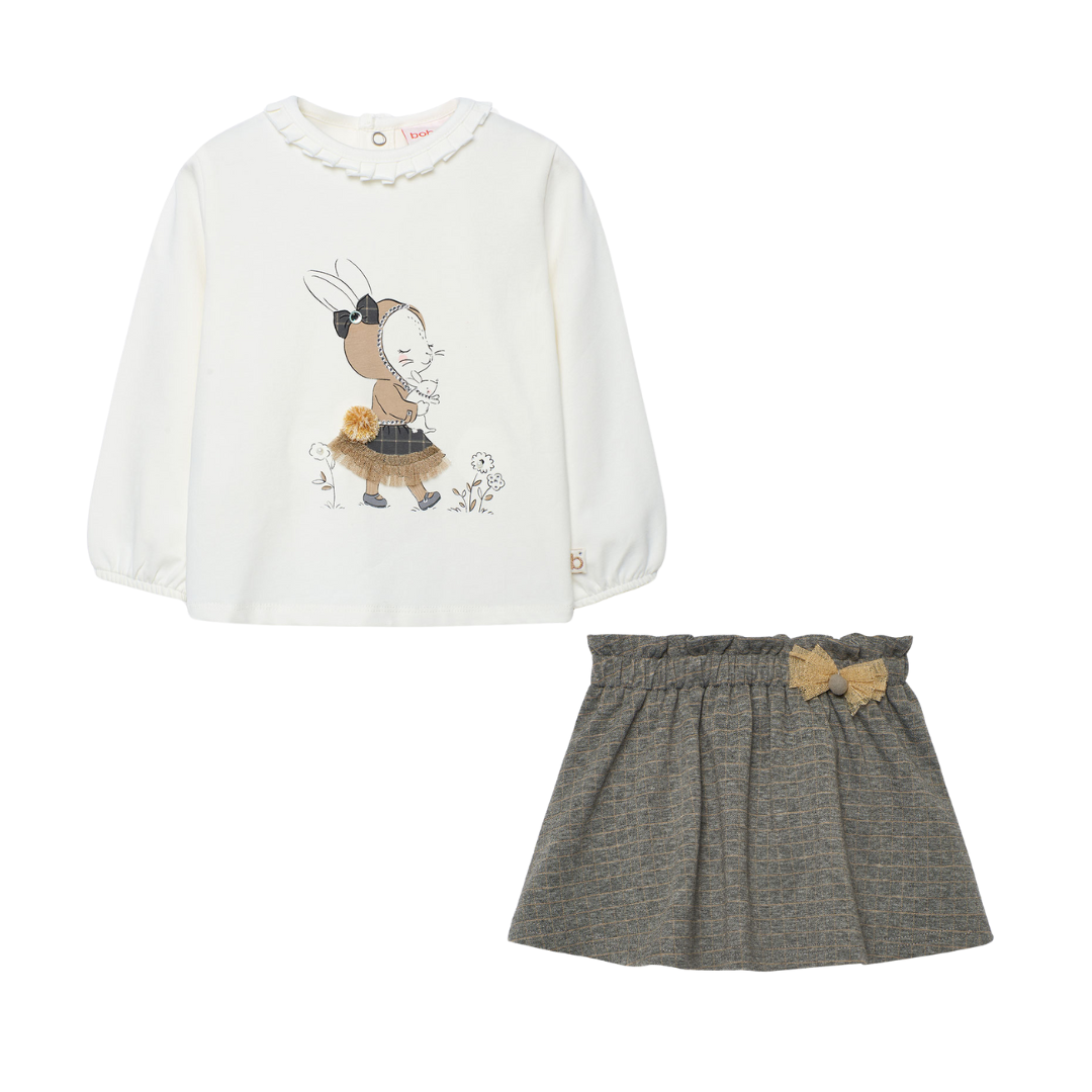 White long-sleeve shirt with cartoon design and gray skirt with bow on a white background