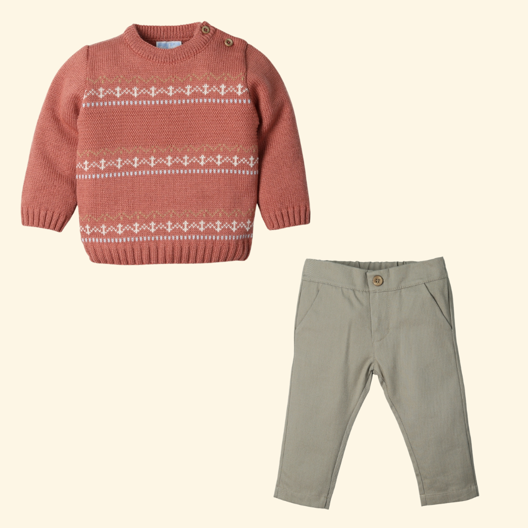 Orange sweater with white pattern and green pants on a beige background