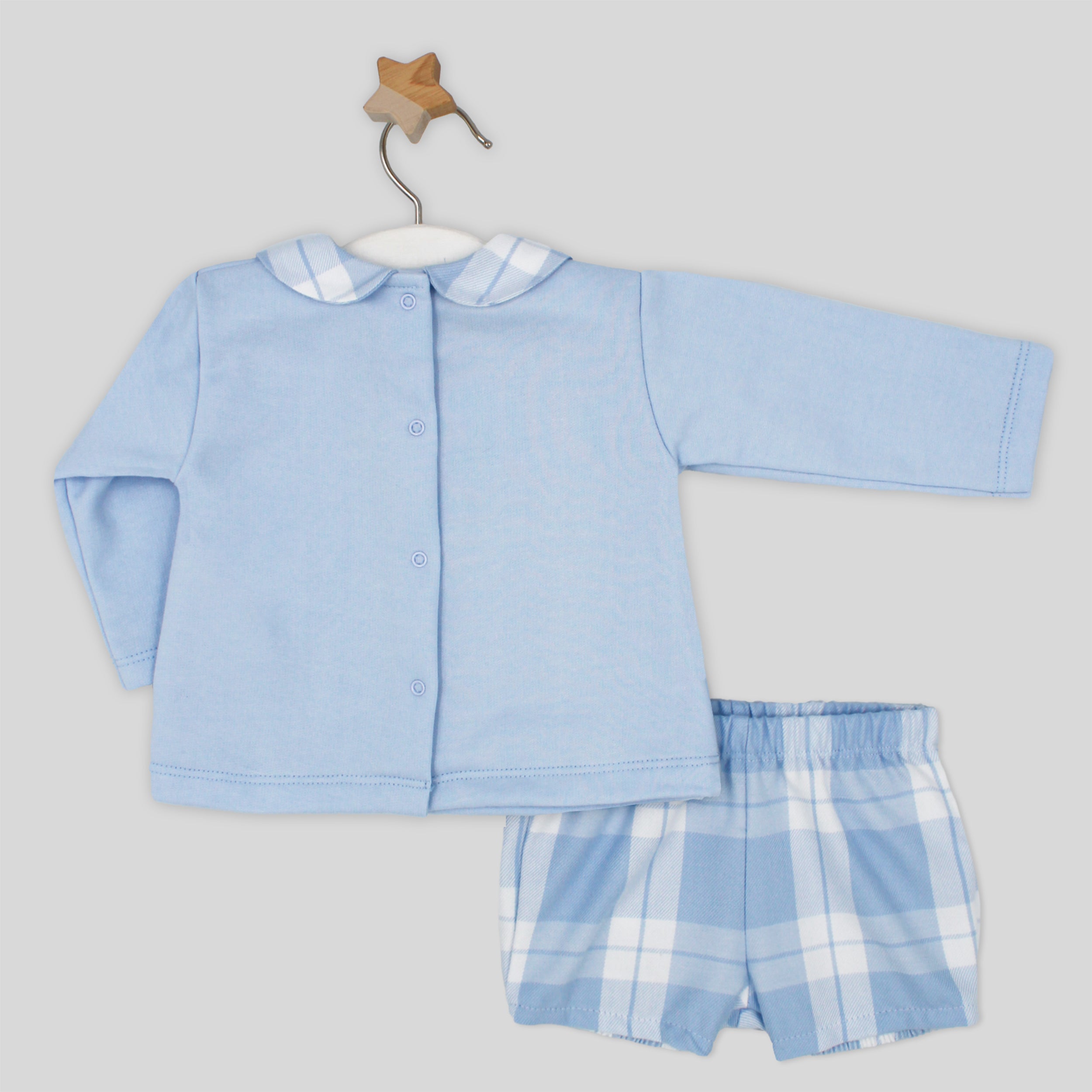 Baby outfit with blue shirt and checkered shorts on a hanger against a light gray background