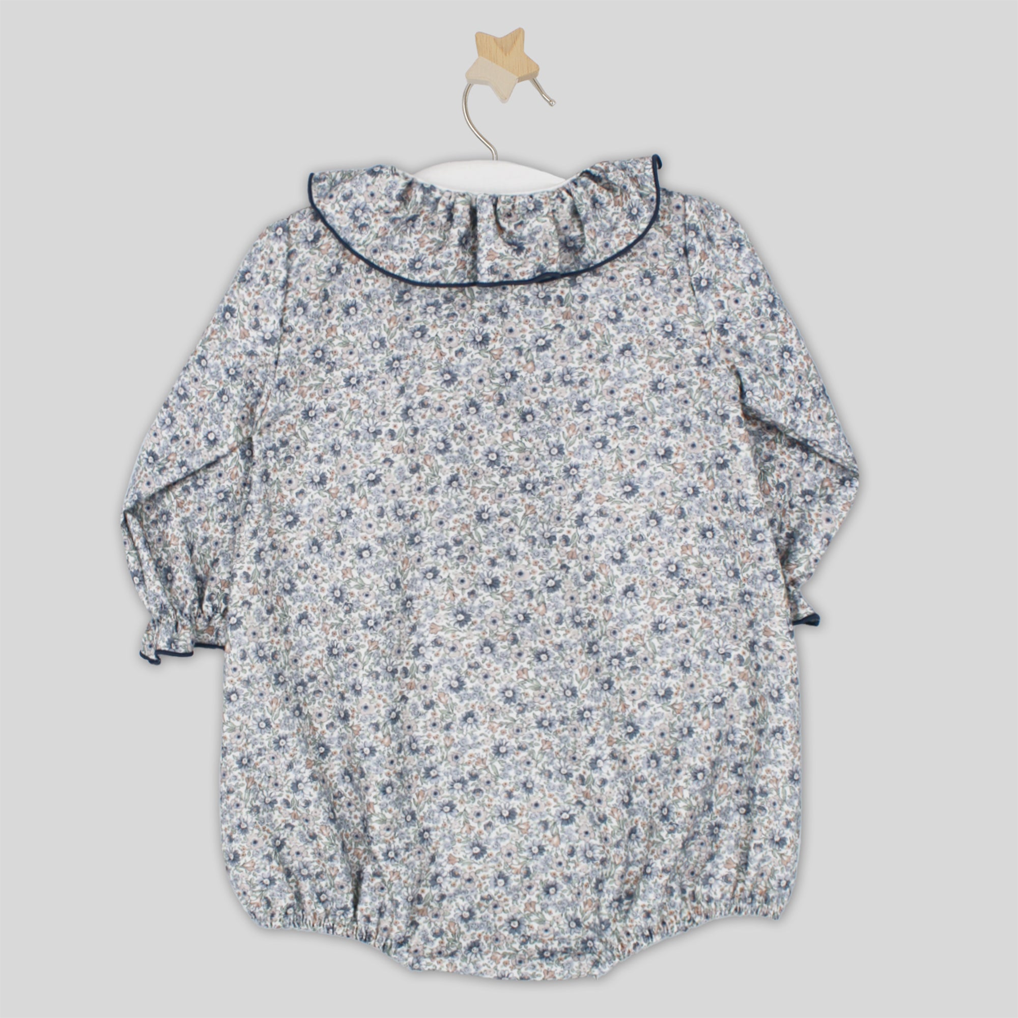 Floral-patterned baby romper on a light gray background