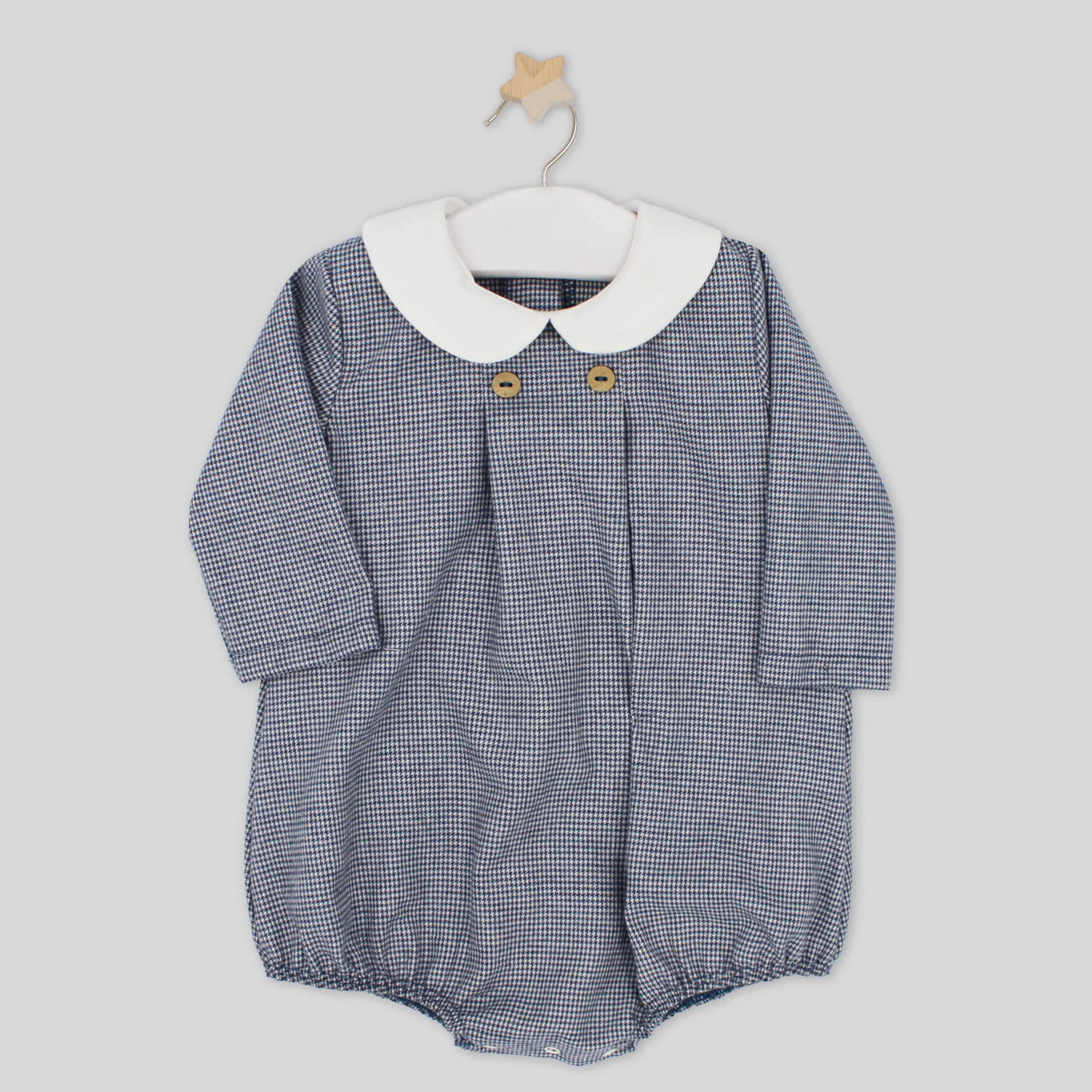 Blue checkered baby romper with white collar on a hanger against a light gray background
