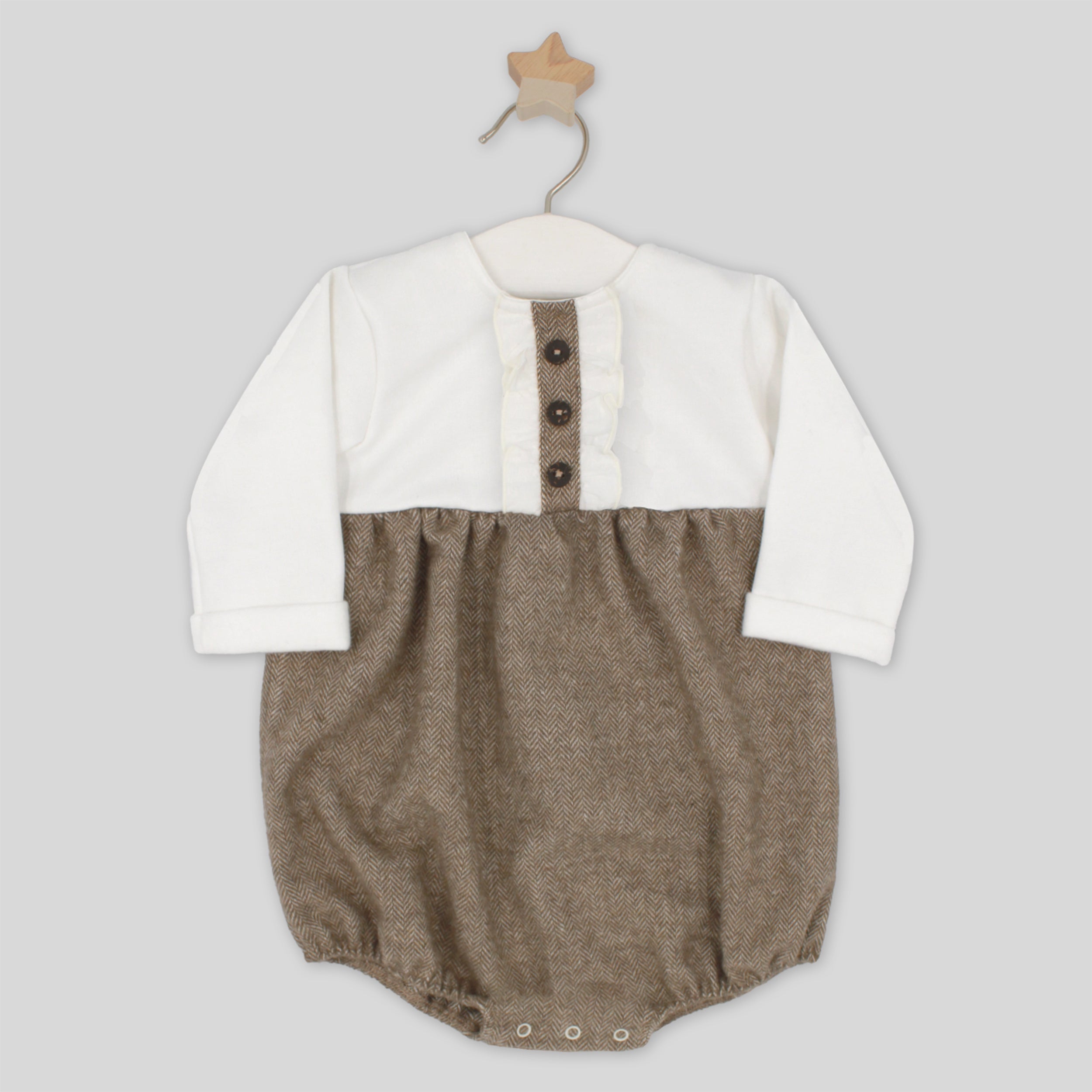 Baby romper with white shirt and brown pants on a hanger against a light gray background