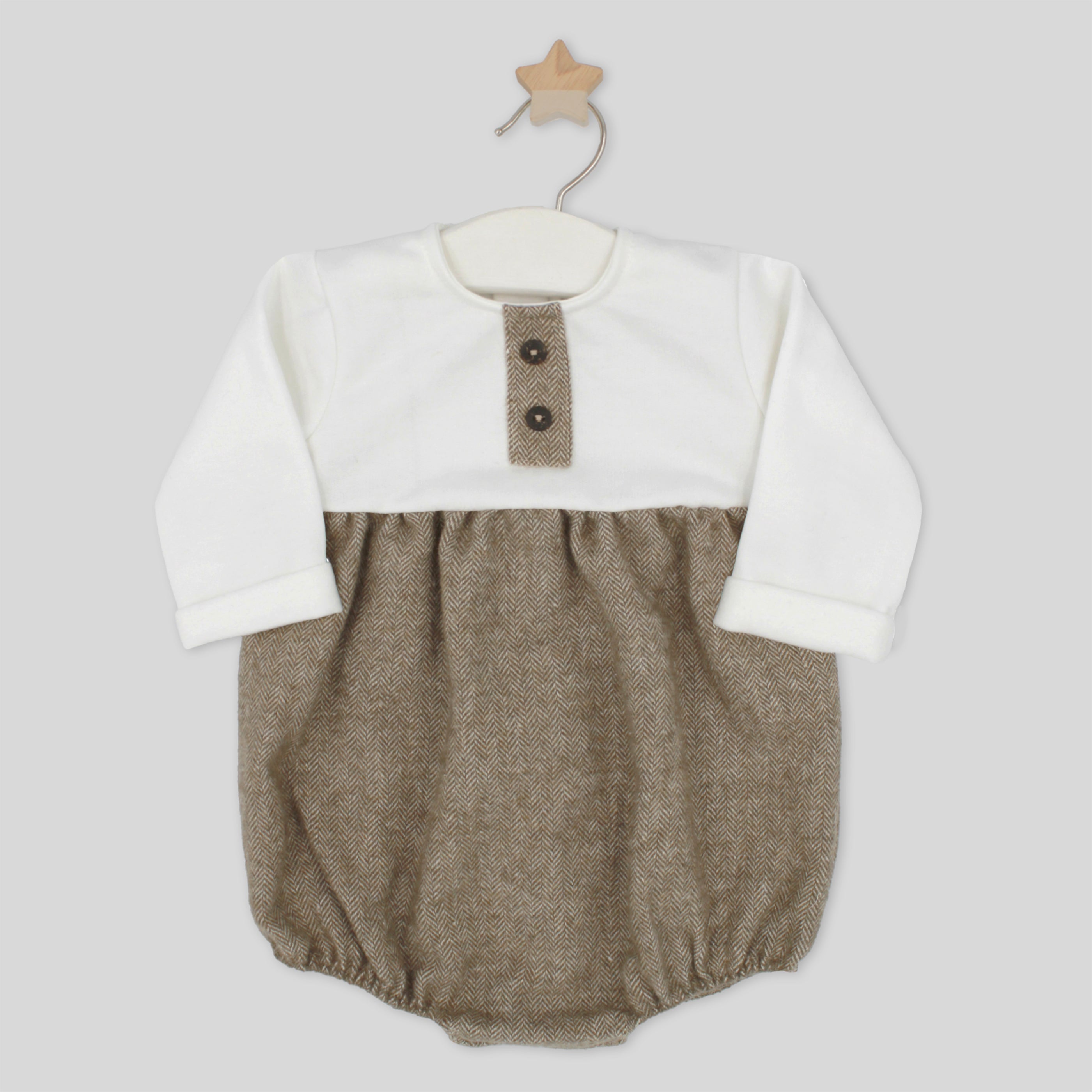 Baby romper with white top and brown bottom on a hanger against a light gray background