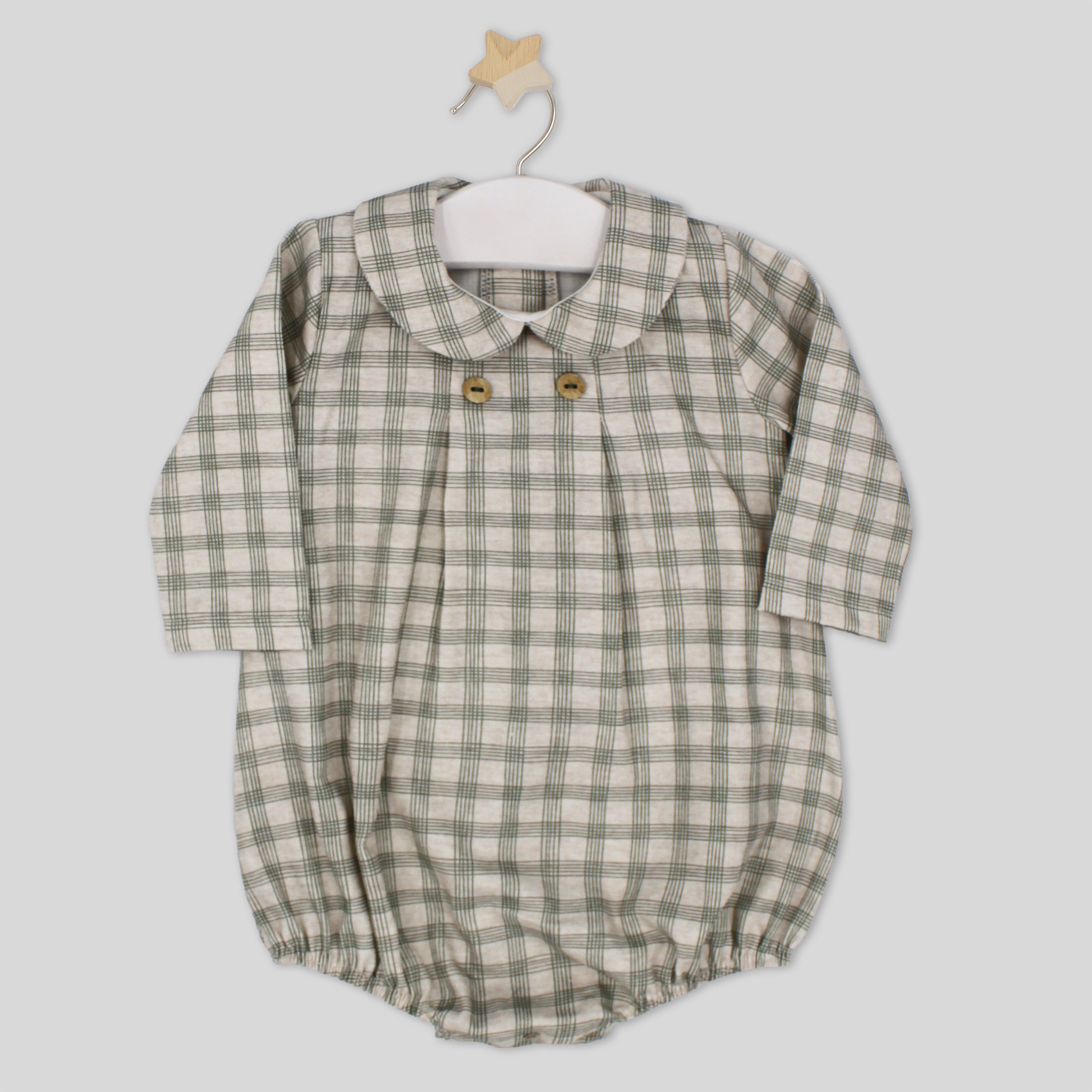 Plaid baby romper with button details on a hanger against a light gray background