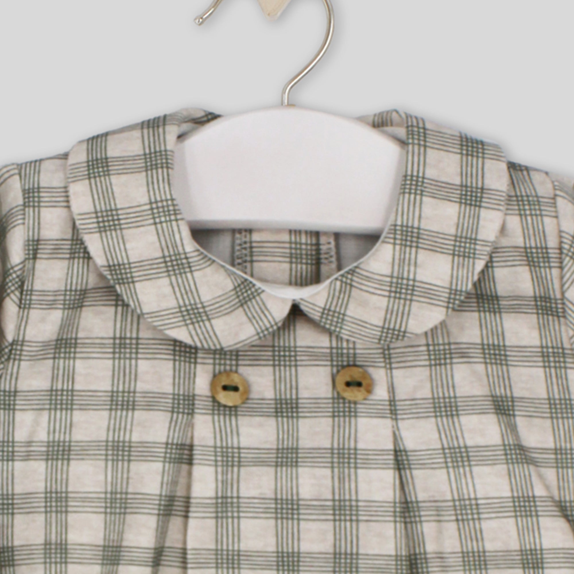 Plaid shirt with a collar on a hanger against a white background