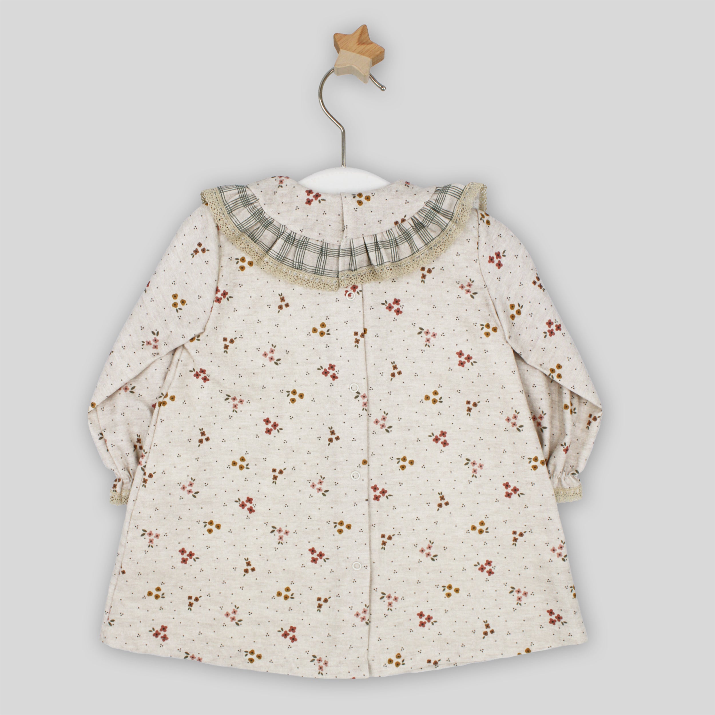 Floral-patterned dress on a hanger against a light gray background