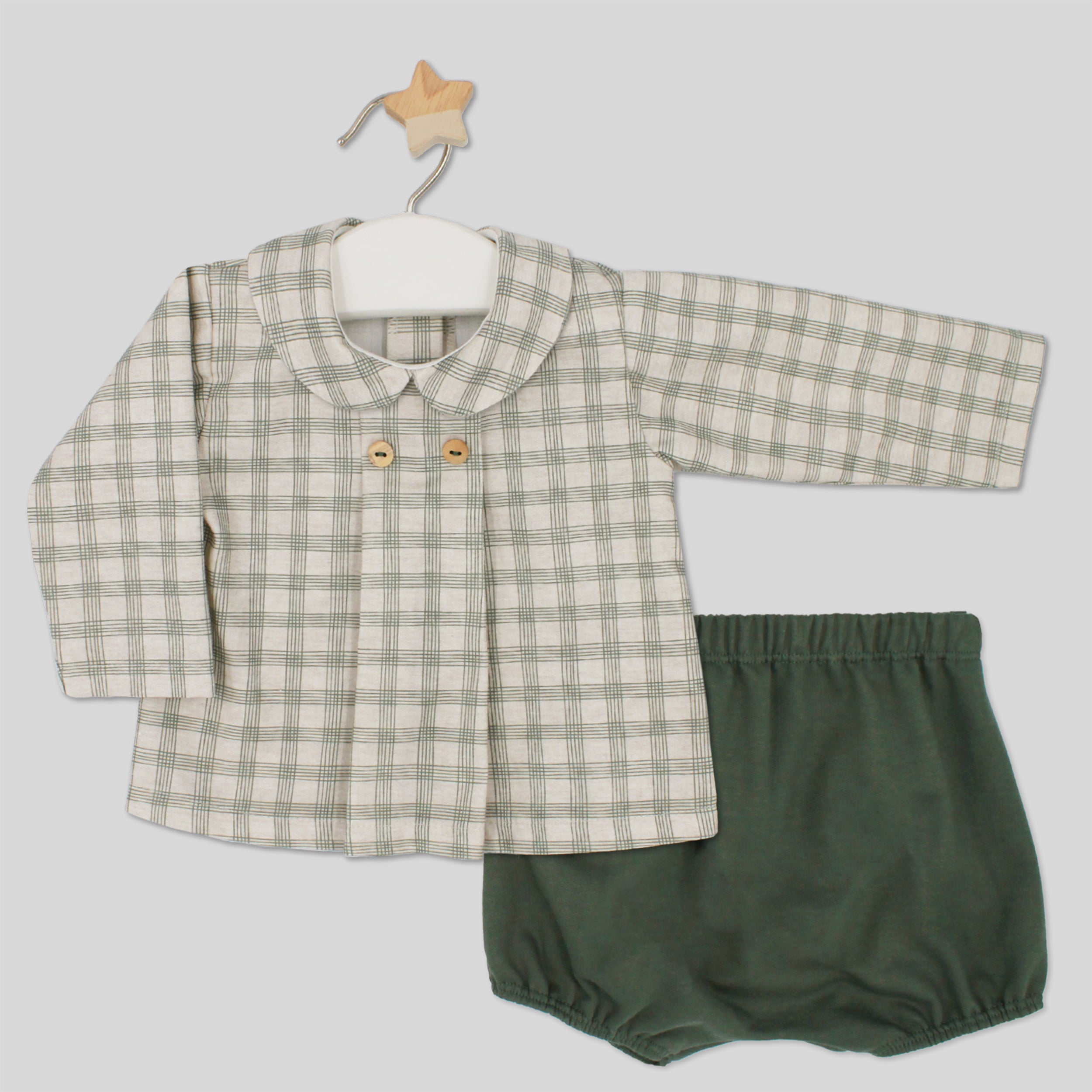 Baby outfit with checkered shirt and green bloomers on a white background