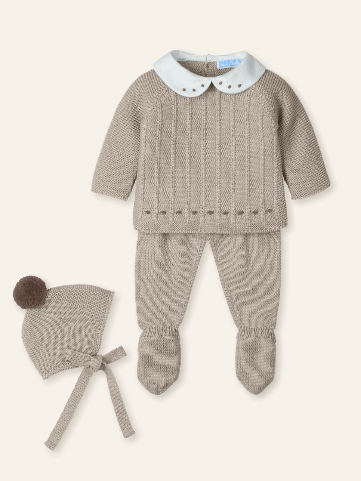 Baby outfit with knitted sweater and pants, and matching hat on a white background